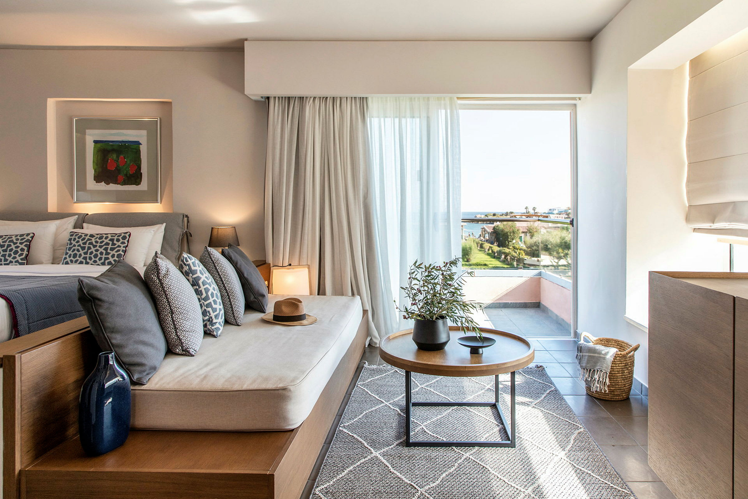 Bild av ett modernt hotellrum med sittmöbel och utsikt över landskap genom ett stort fönster. (AI-genererad text)