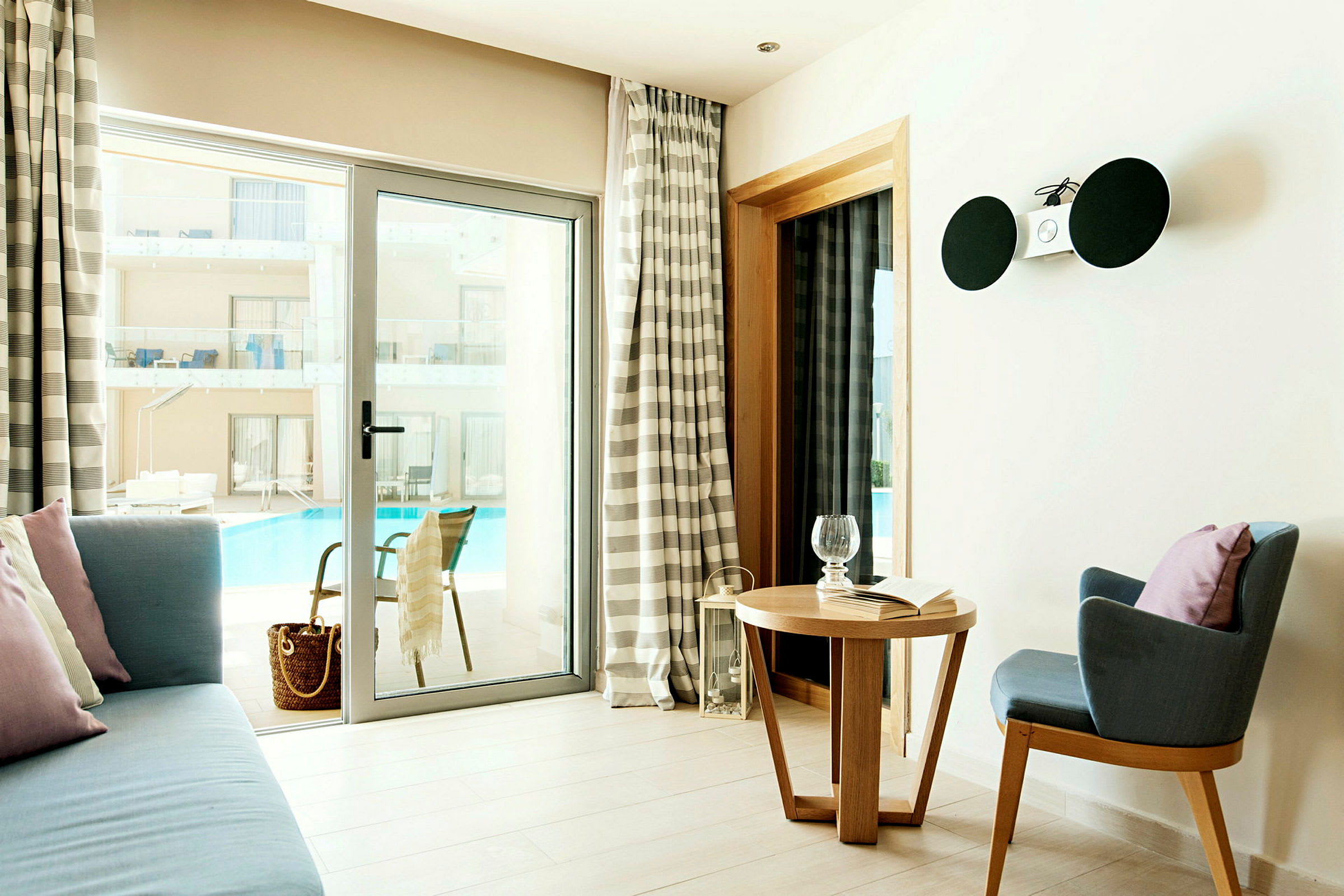 Ett hotellrum med en sittgrupp och utsikt mot poolen. (AI-genererad text)