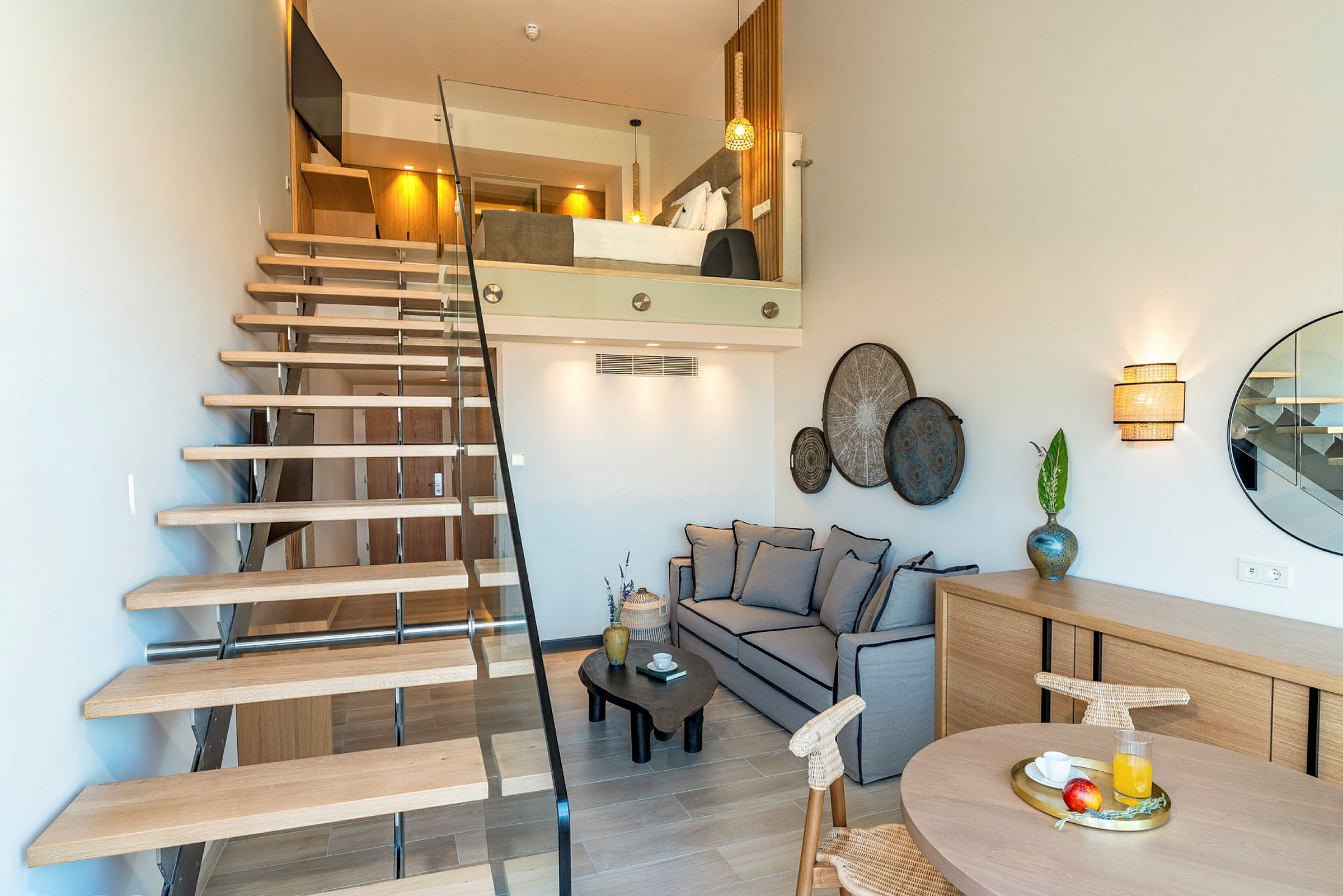 En modern lägenhet med loft innehållande säng, sittgrupp, dekorativt bord och dekorerad vägg. (AI-genererad text)