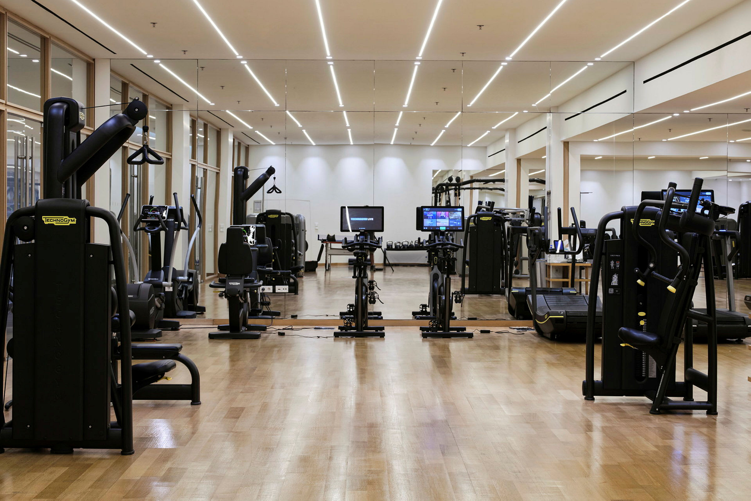 Gym med träningsmaskiner och spegelvägg. (AI-genererad text)