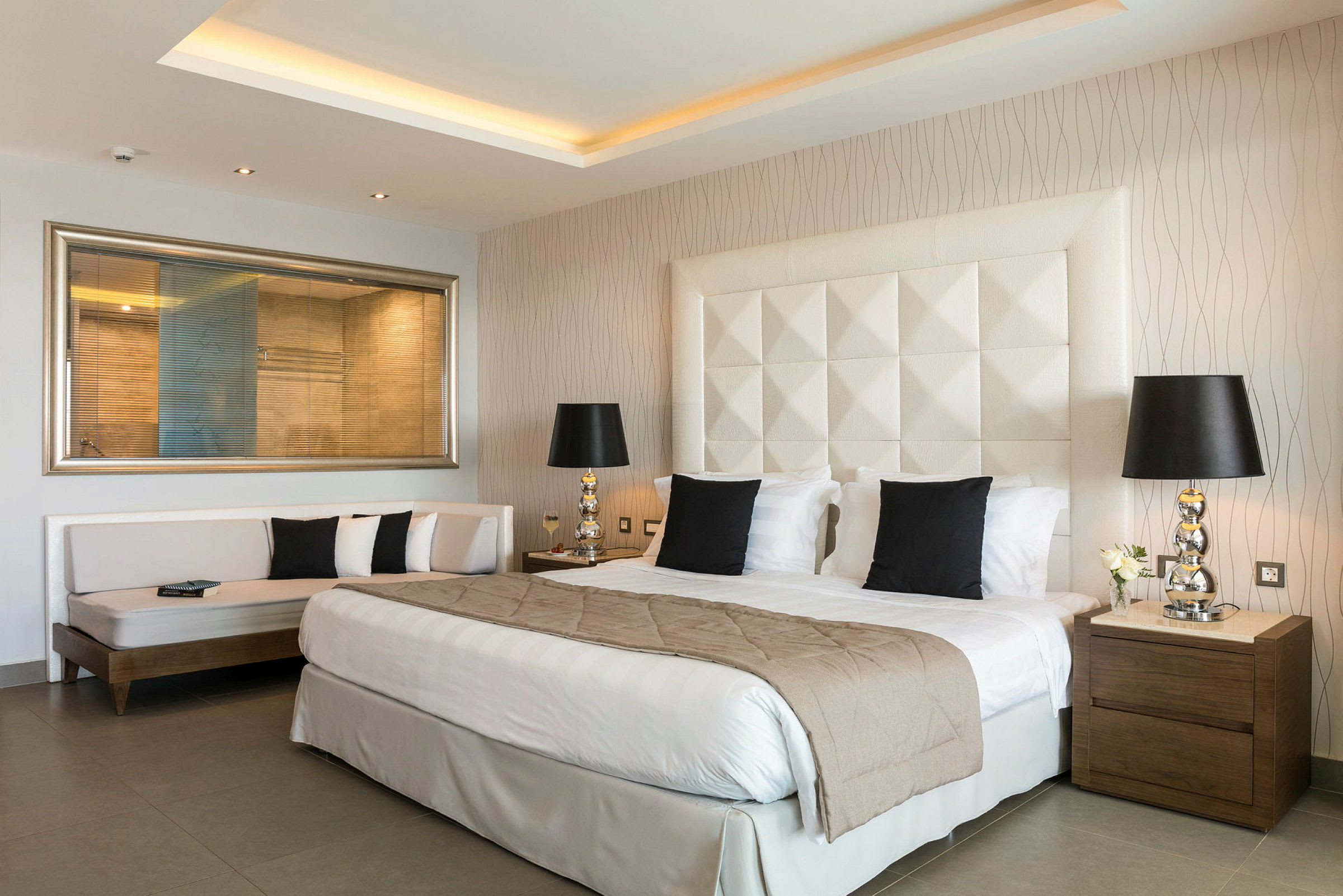 En modern hotellrum med en stor säng och stilfulla möbler. (AI-genererad text)