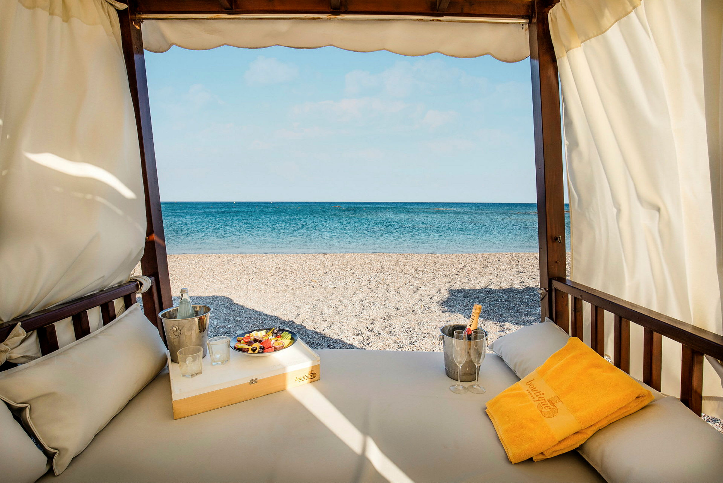 Utsikt från en solsäng mot en strand med blått hav i bakgrunden. (AI-genererad text)