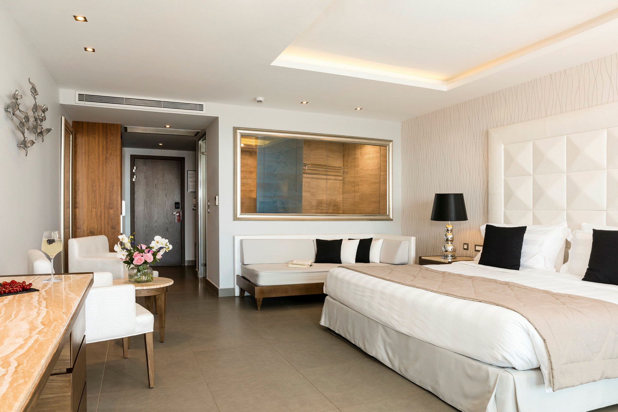 Ett hotellrum med en stor säng, soffa och sittgrupp. (AI-genererad text)