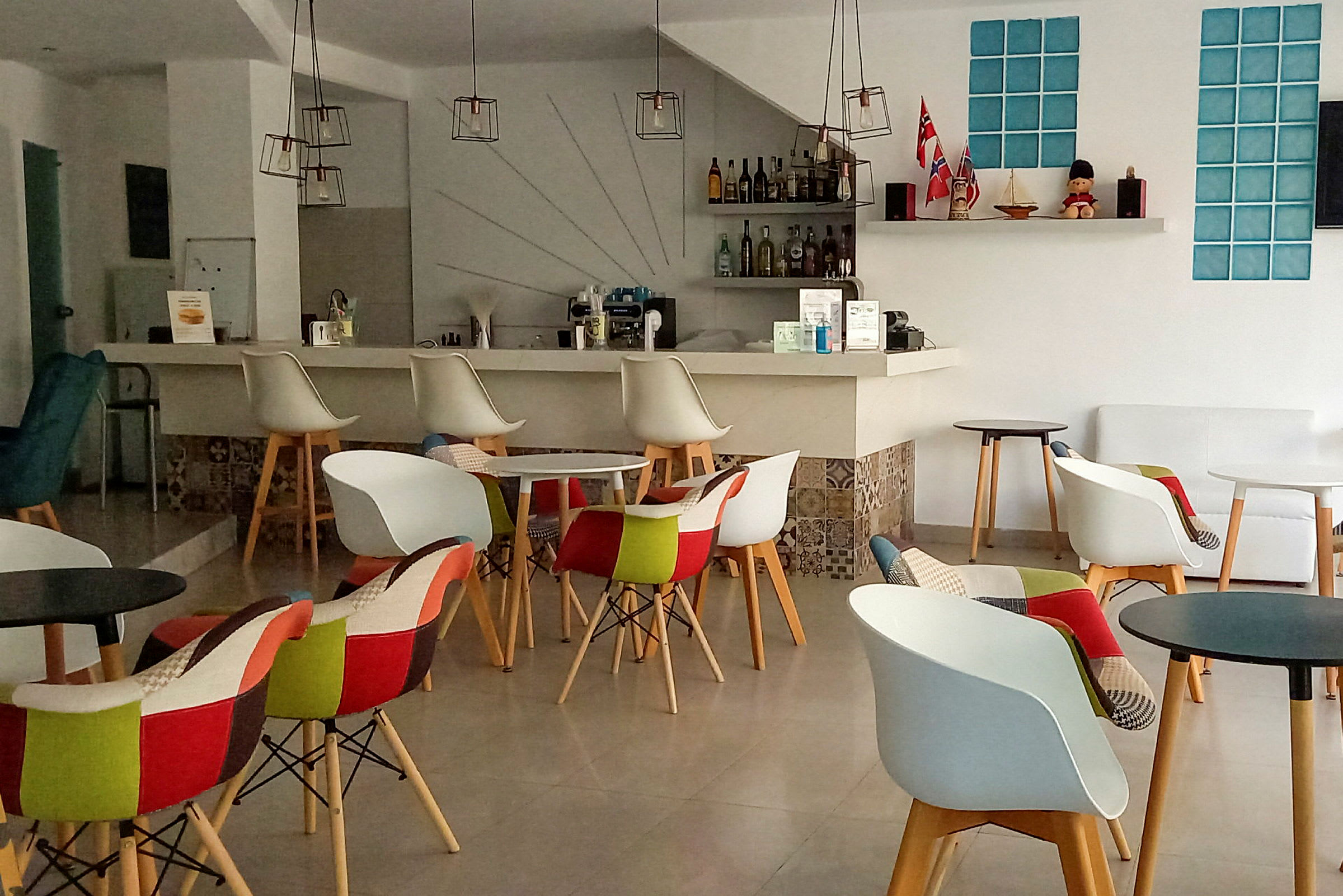 Interiör av en modern kaffebar med färgglada stolar och små bord. (AI-genererad text)