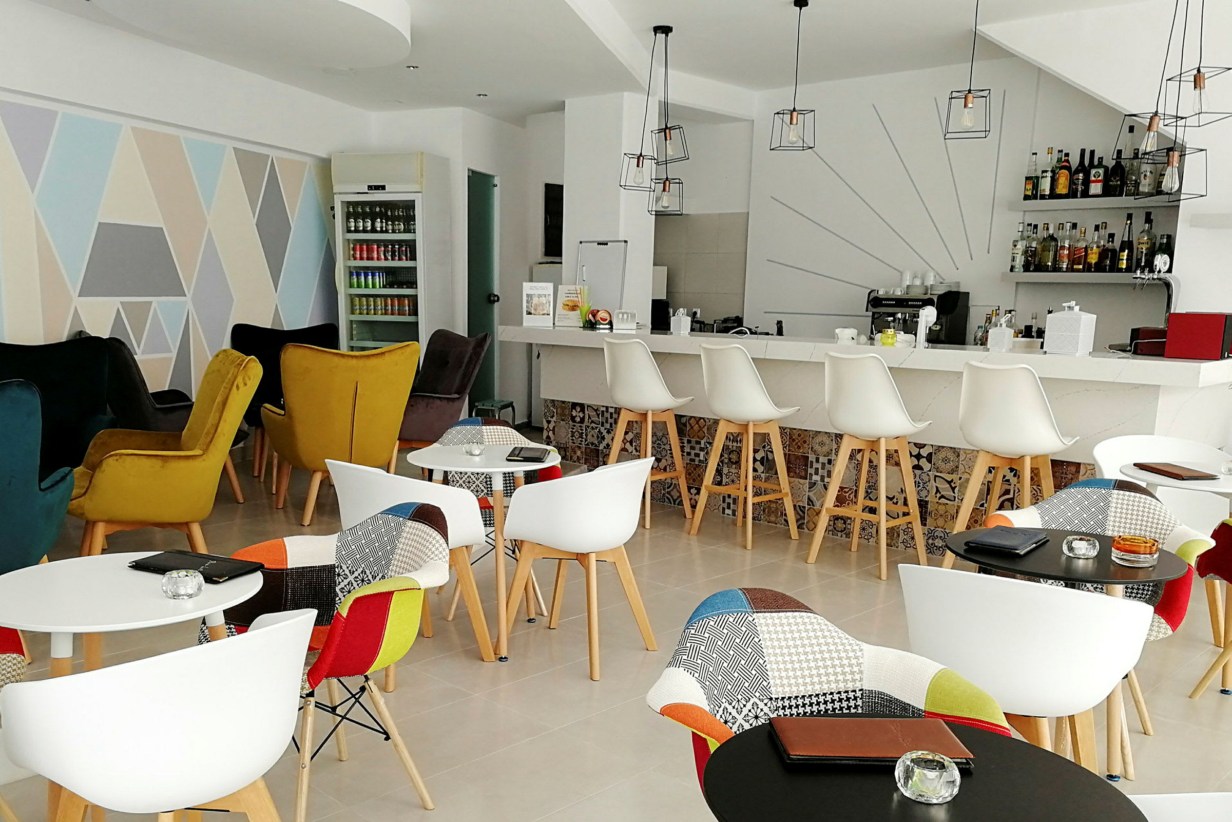Inomhusvy av ett stilfullt café med färgglada stolar, ett barområde och dekorativa element. (AI-genererad text)