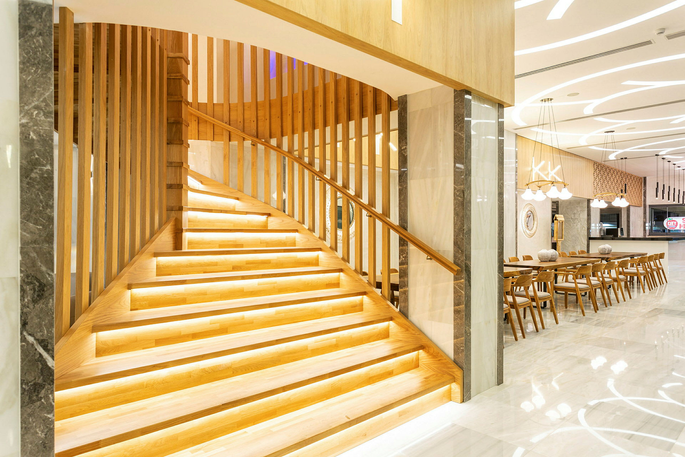 Elegant trappa av trä med belysning och en modern restaurangmiljö. (AI-genererad text)