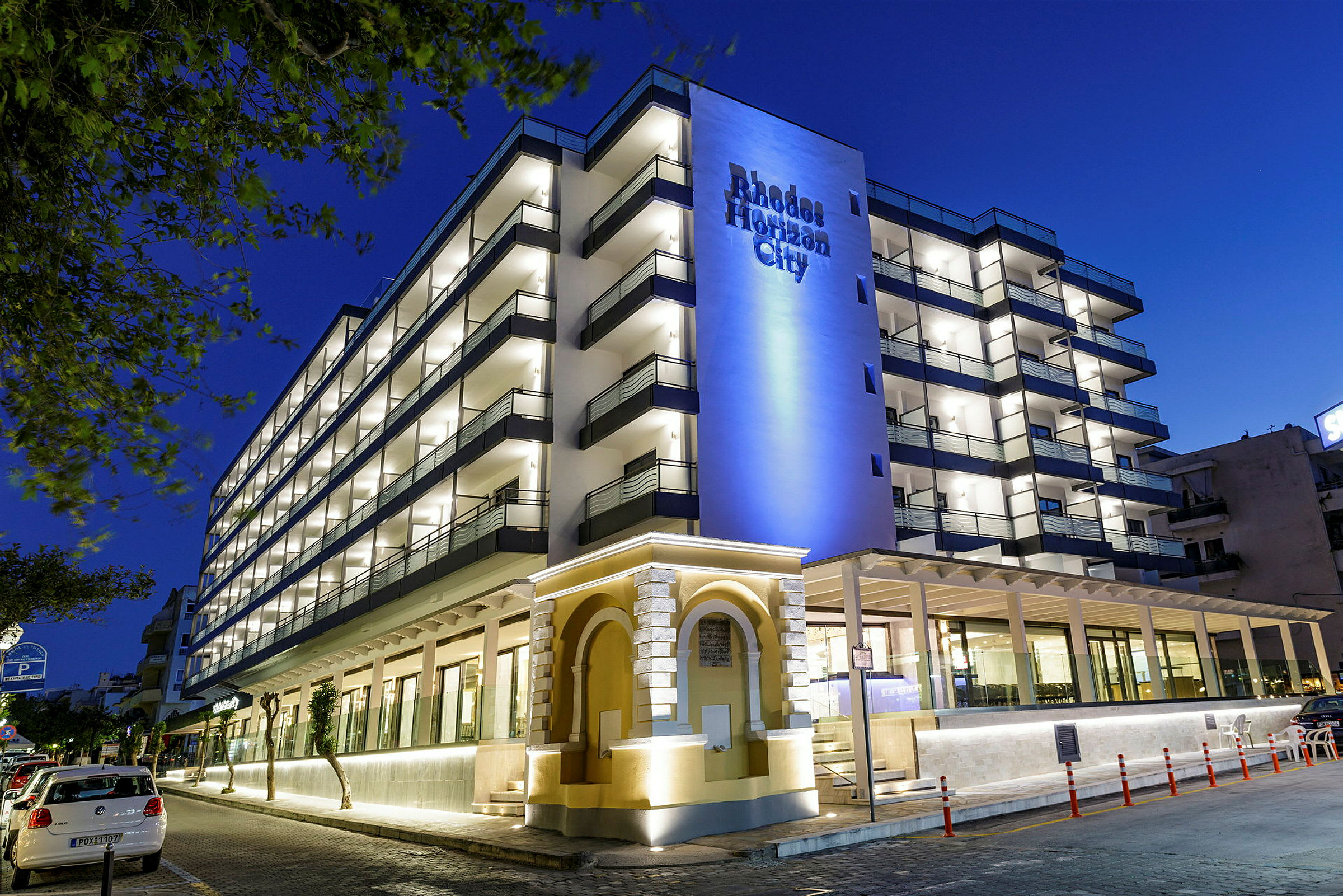 Hotellbyggnad med flera våningar och upplyst fasad på kvällen. (AI-genererad text)