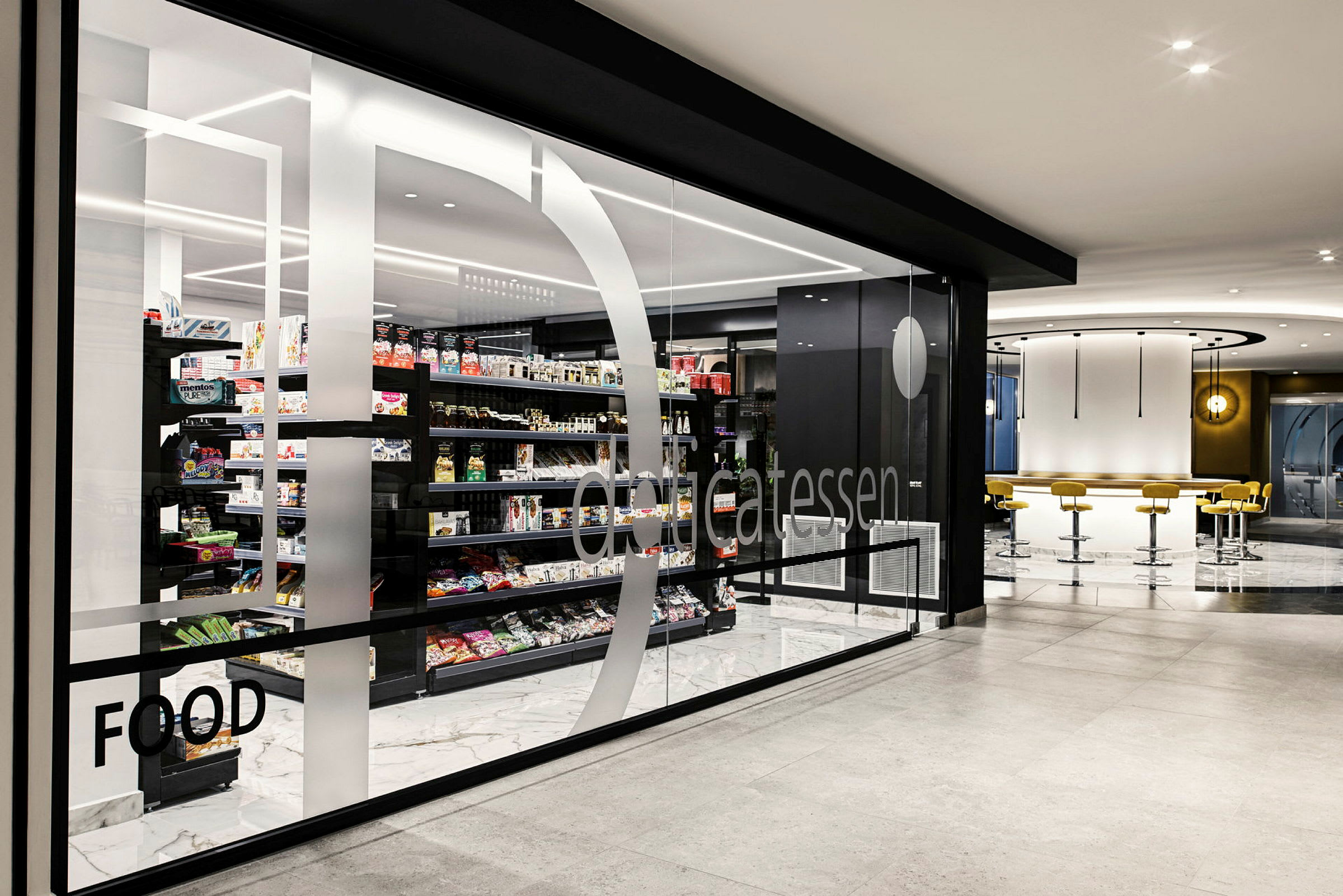 Inredning av en modern livsmedelsbutik med glasvägg och varor på hyllor. (AI-genererad text)
