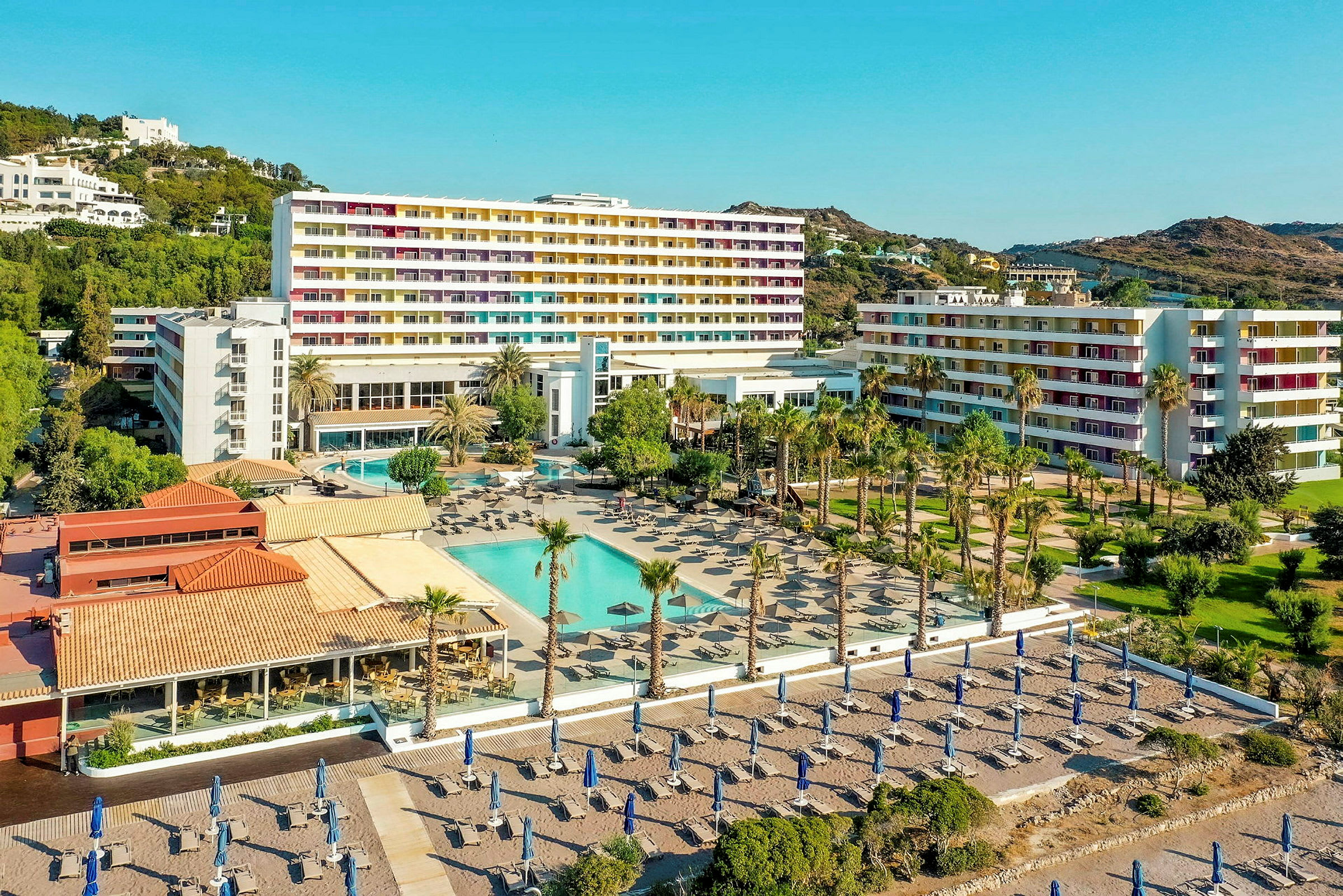 Hotellområde med pool, solstolar och sandstrand i bakgrunden. (AI-genererad text)