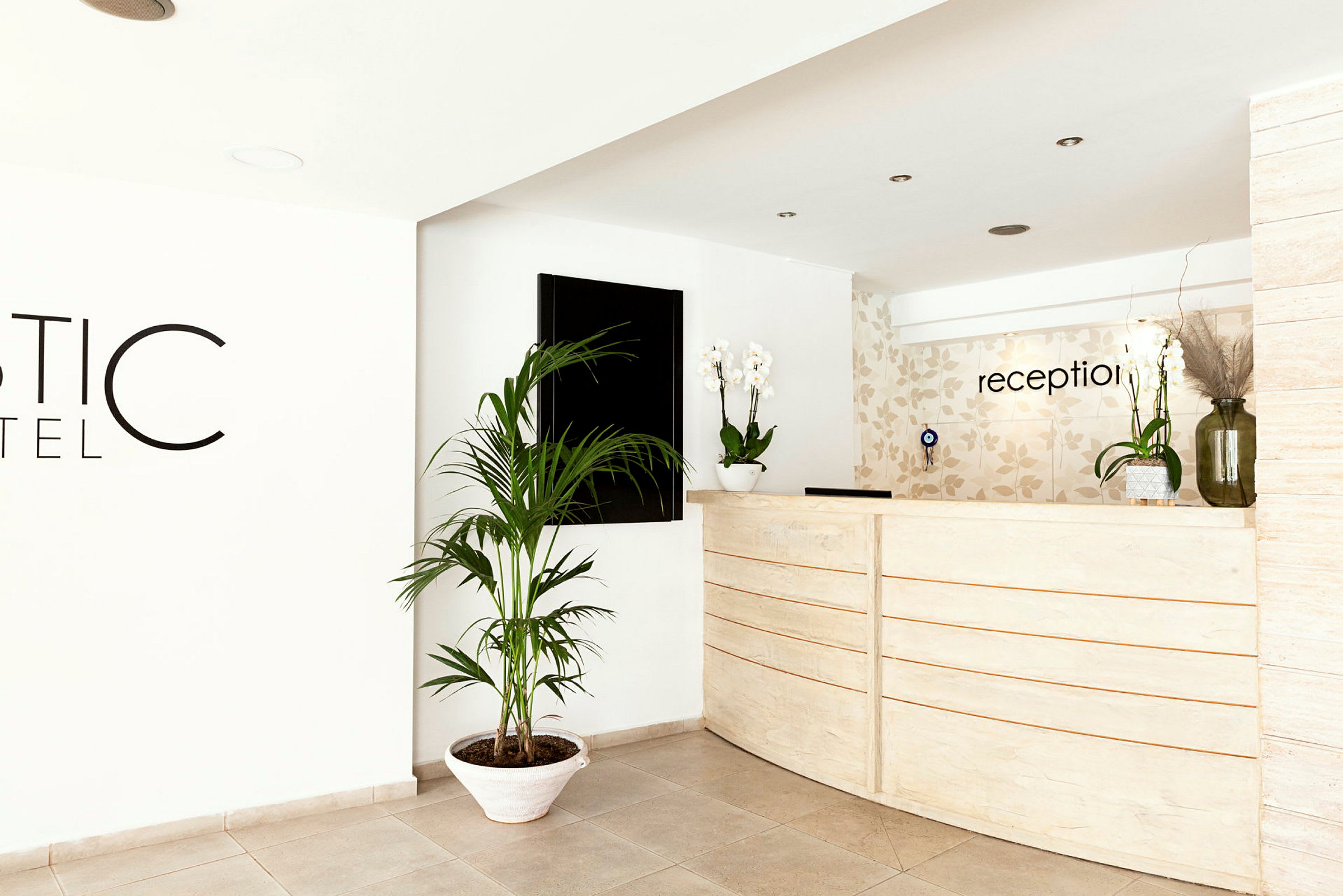 Reception med en vit diskmöbel och dekorativa växter. (AI-genererad text)