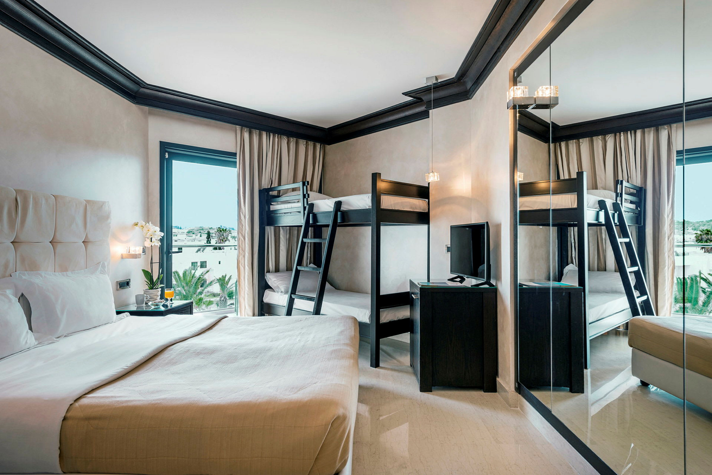 Hotellrum med dubbelsäng, våningssäng och fönster med utsikt. (AI-genererad text)