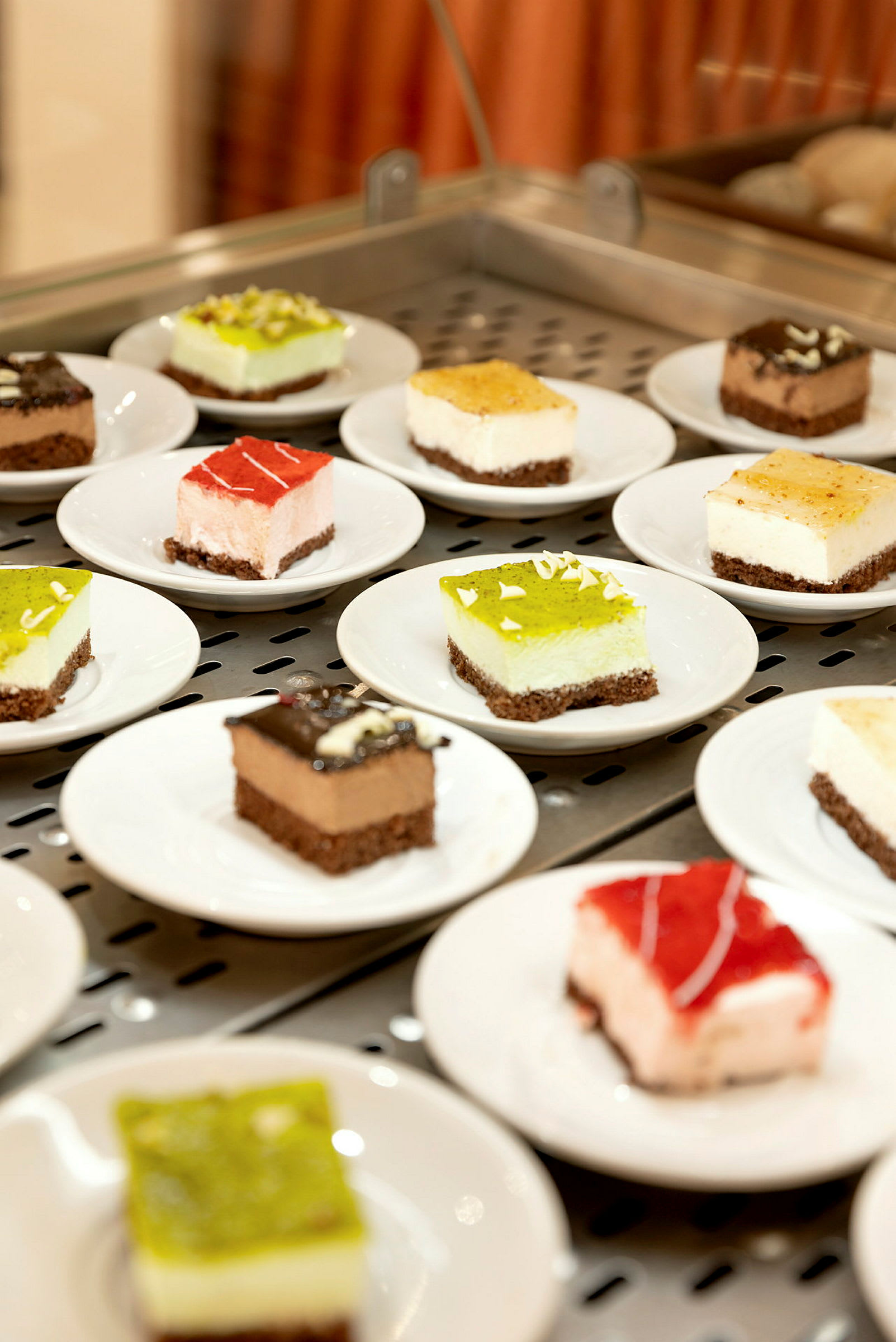 Flera små desserter på vita tallrikar, presenterade på en serveringsyta. (AI-genererad text)