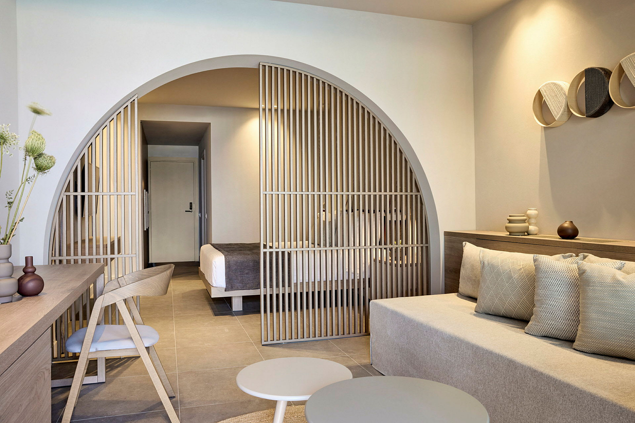 Modernt hotellrum med sittgrupp och avdelare mot sovutrymme. (AI-genererad text)