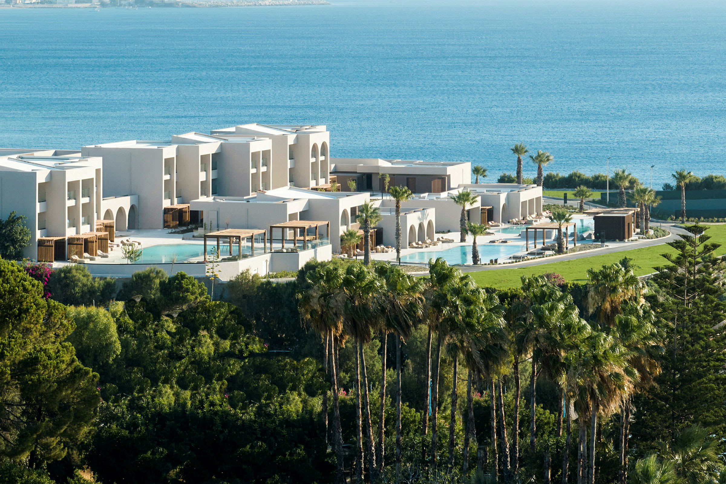 Modern resort med pooler, grönska och havet i bakgrunden. (AI-genererad text)
