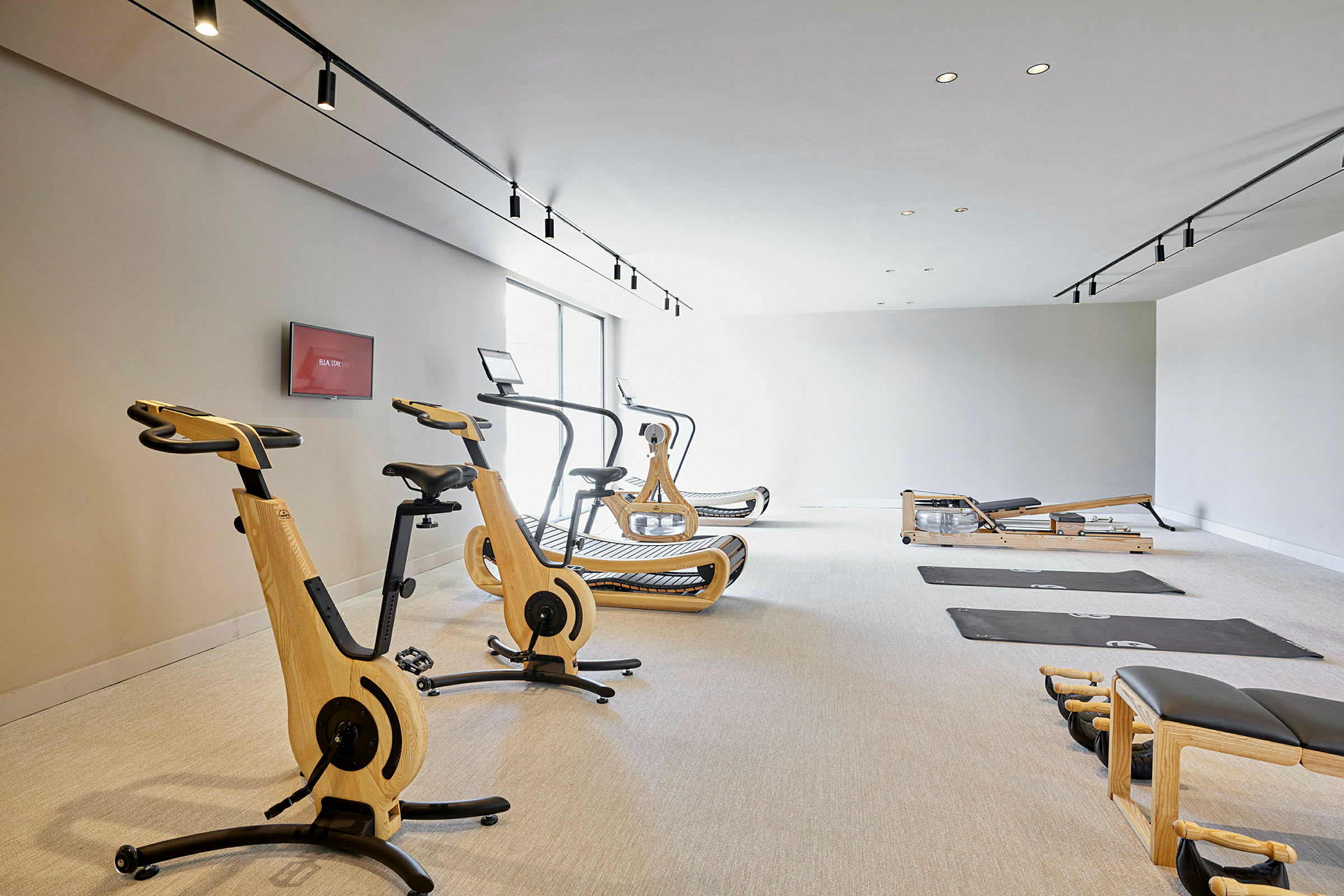 Gym med träningsutrustning inklusive träningscyklar, löpband och mattor. (AI-genererad text)