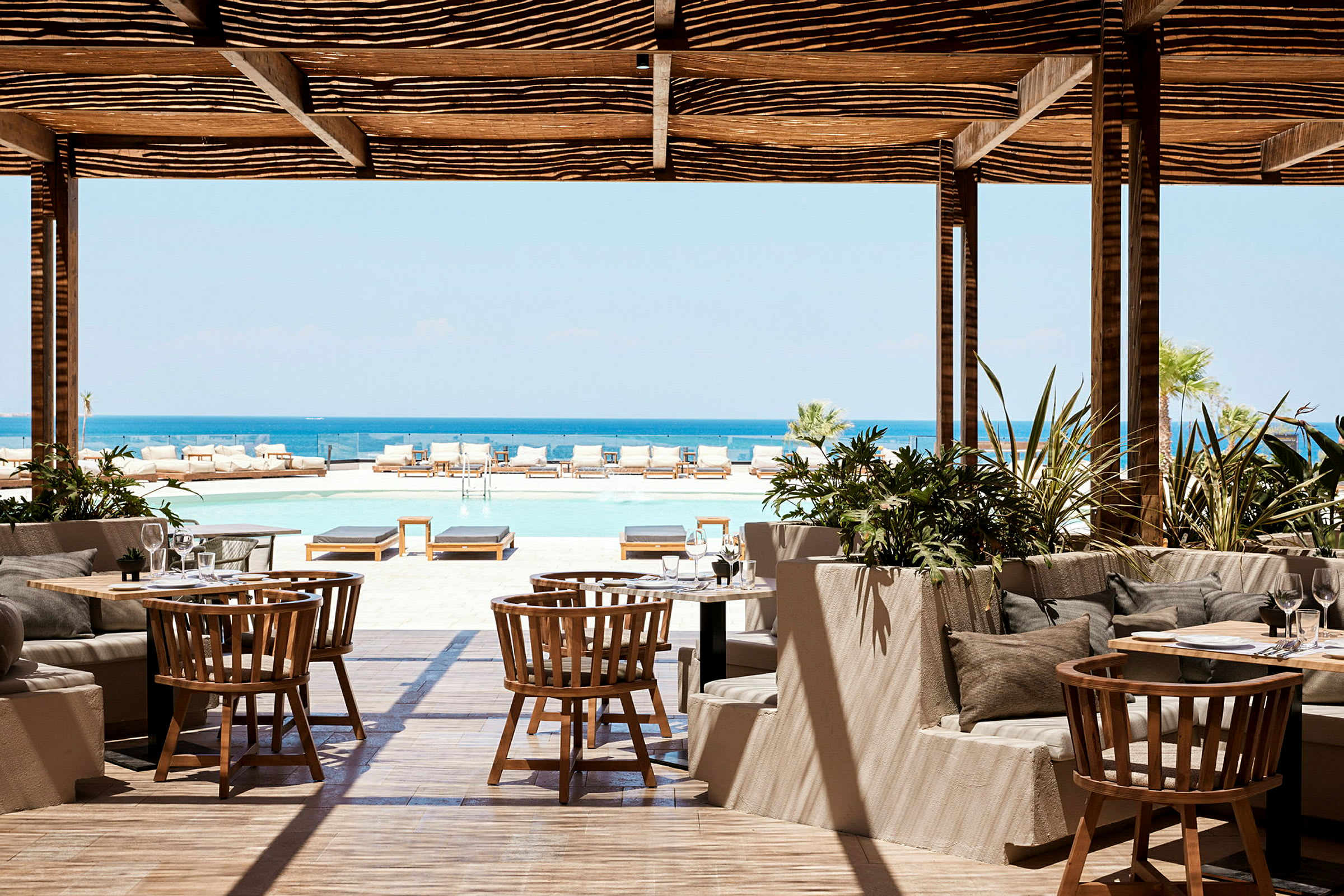 Restaurang med utsikt över en pool och havet. (AI-genererad text)