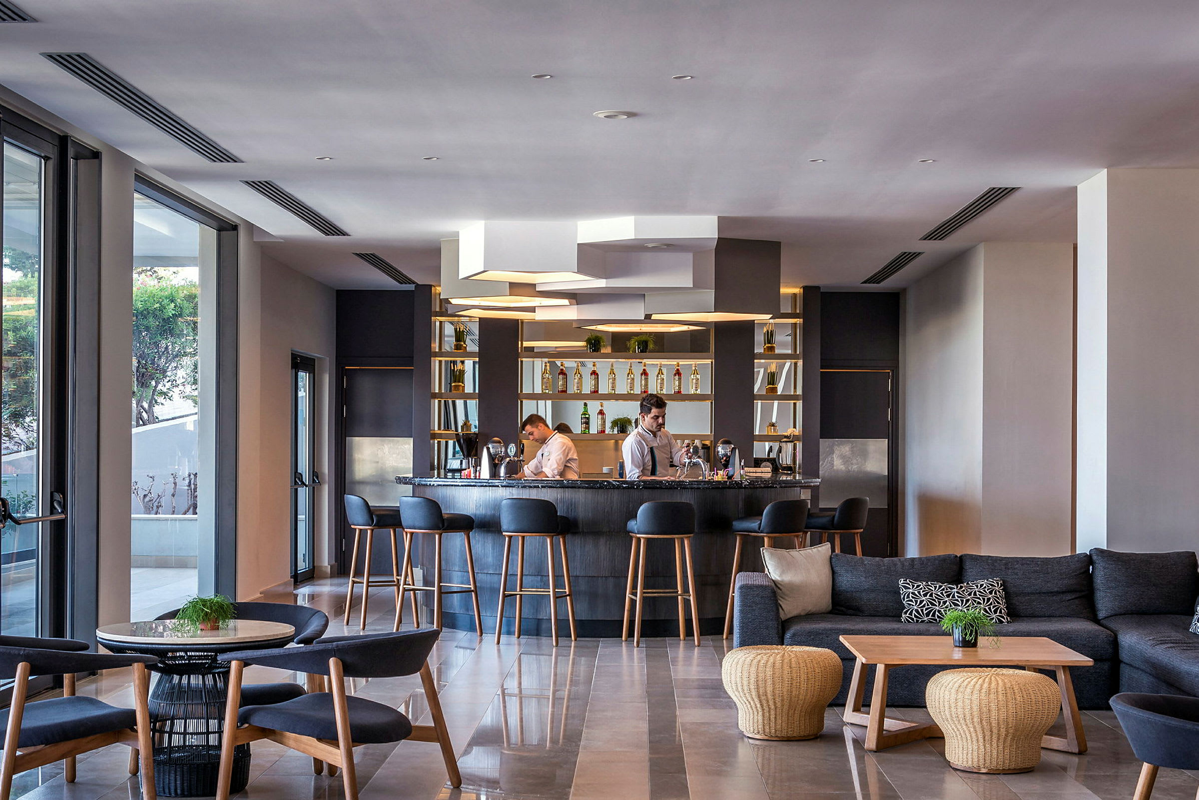 Hotellbar med stolar och soffor, samt personal bakom disken. (AI-genererad text)