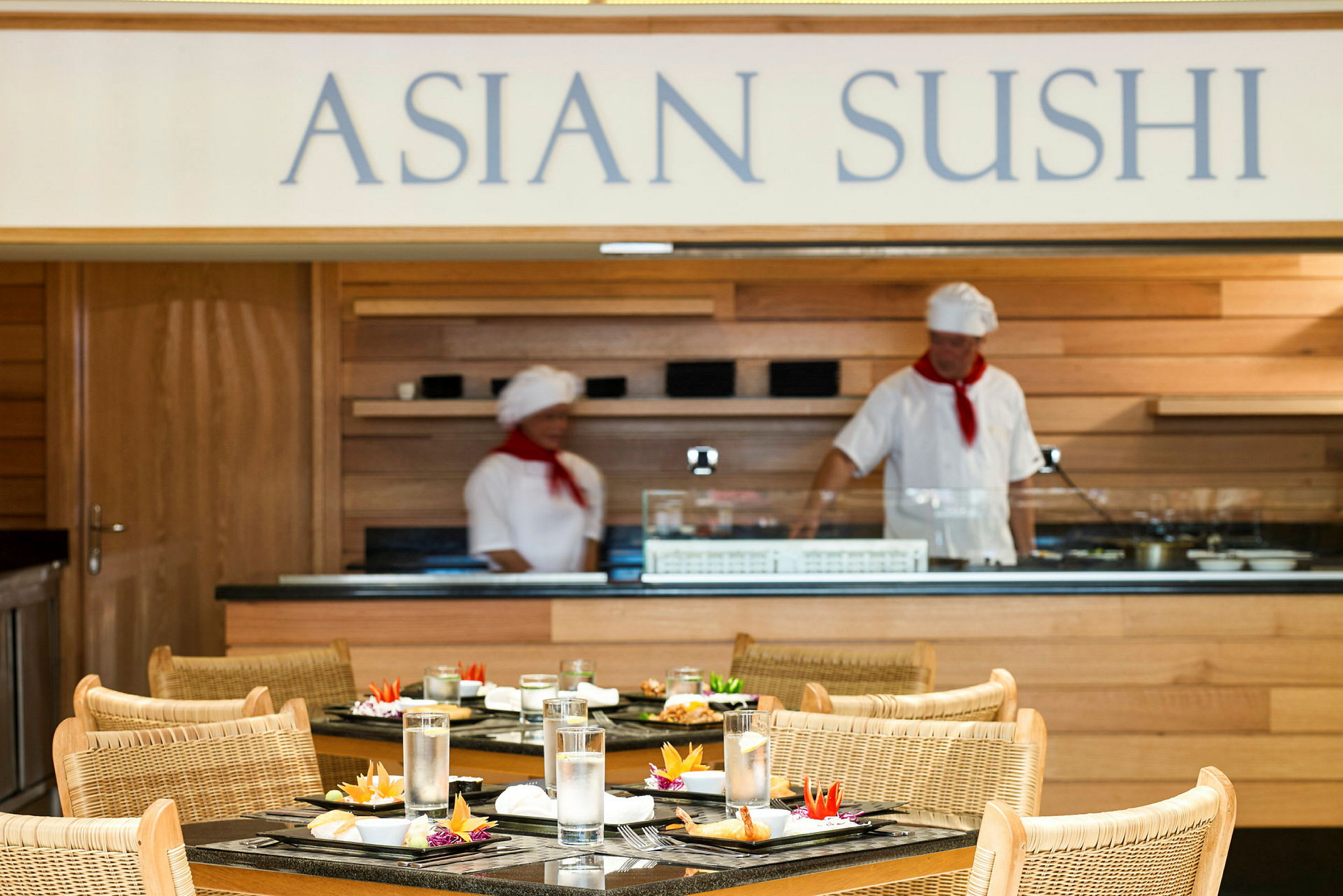 En asiatisk sushirestaurang med dukade bord och en sushibar i trä i bakgrunden. (AI-genererad text)