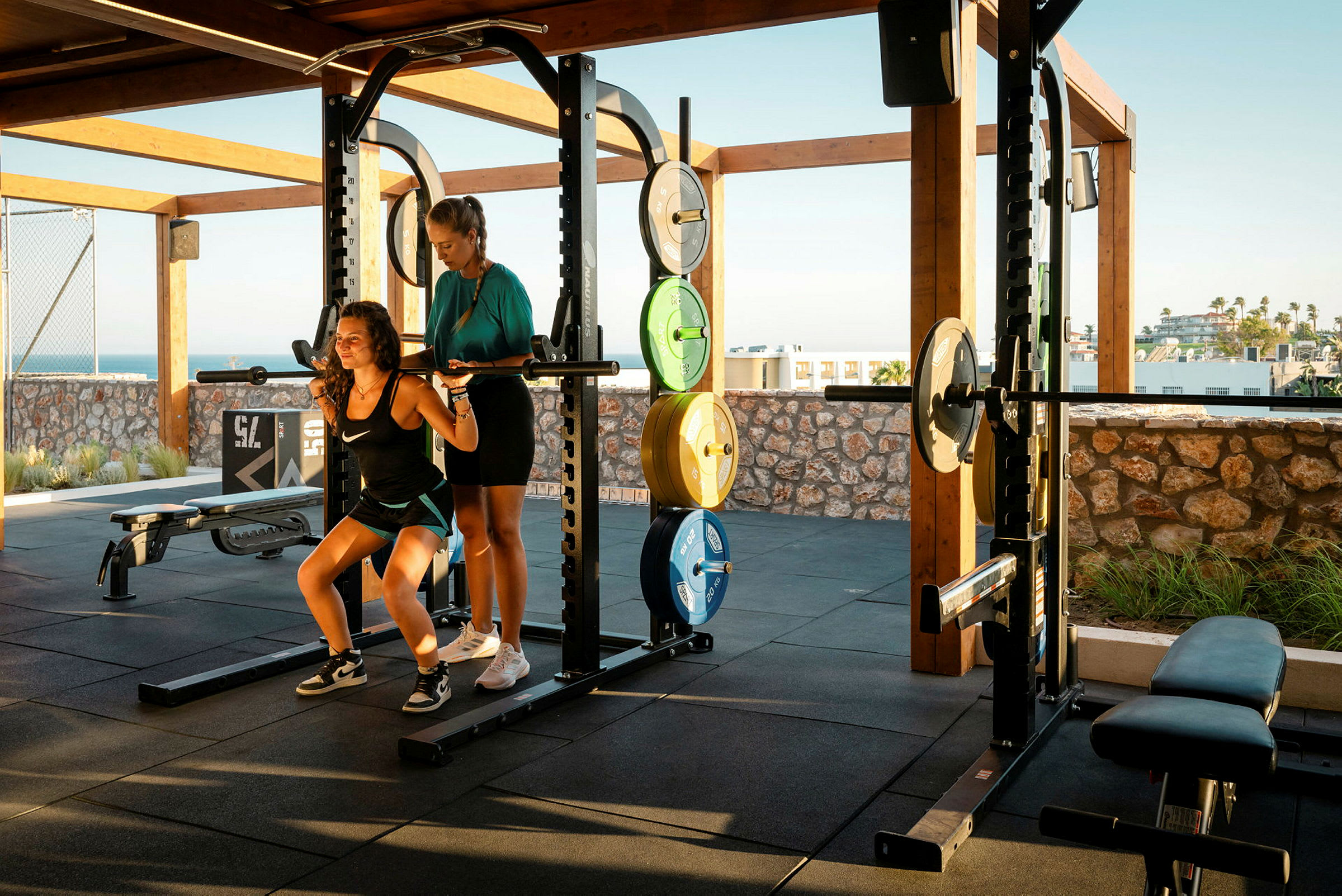 Två personer tränar med skivstång vid ett utomhusgym. (AI-genererad text)