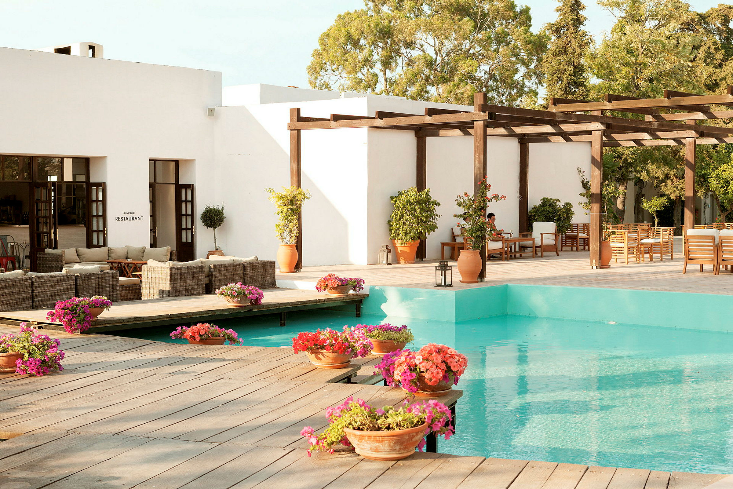 Bild av en uteplats med pool, blommor och sittmöbler. (AI-genererad text)