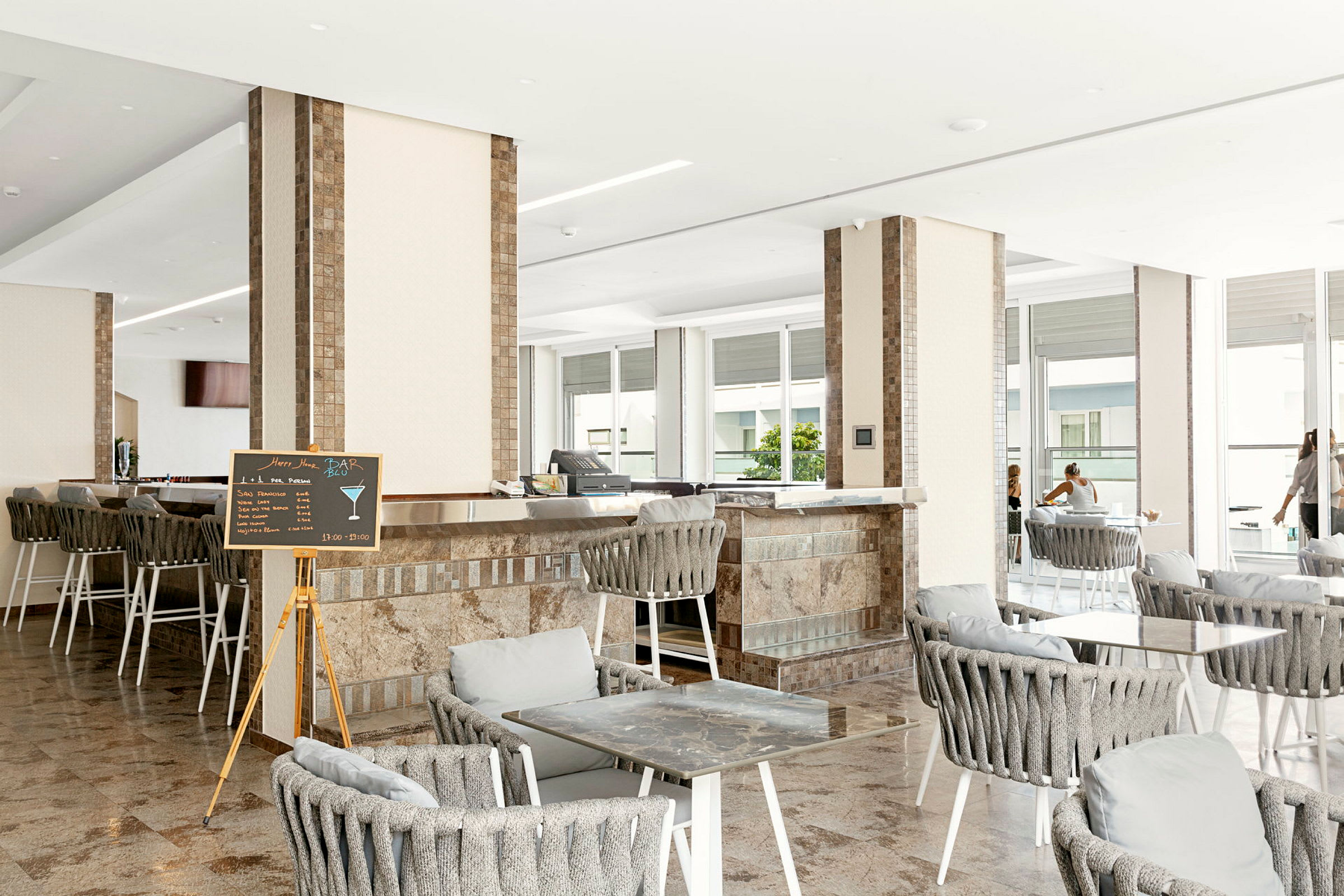 Interiör av en bar/lounge med sittplatser och bord. (AI-genererad text)