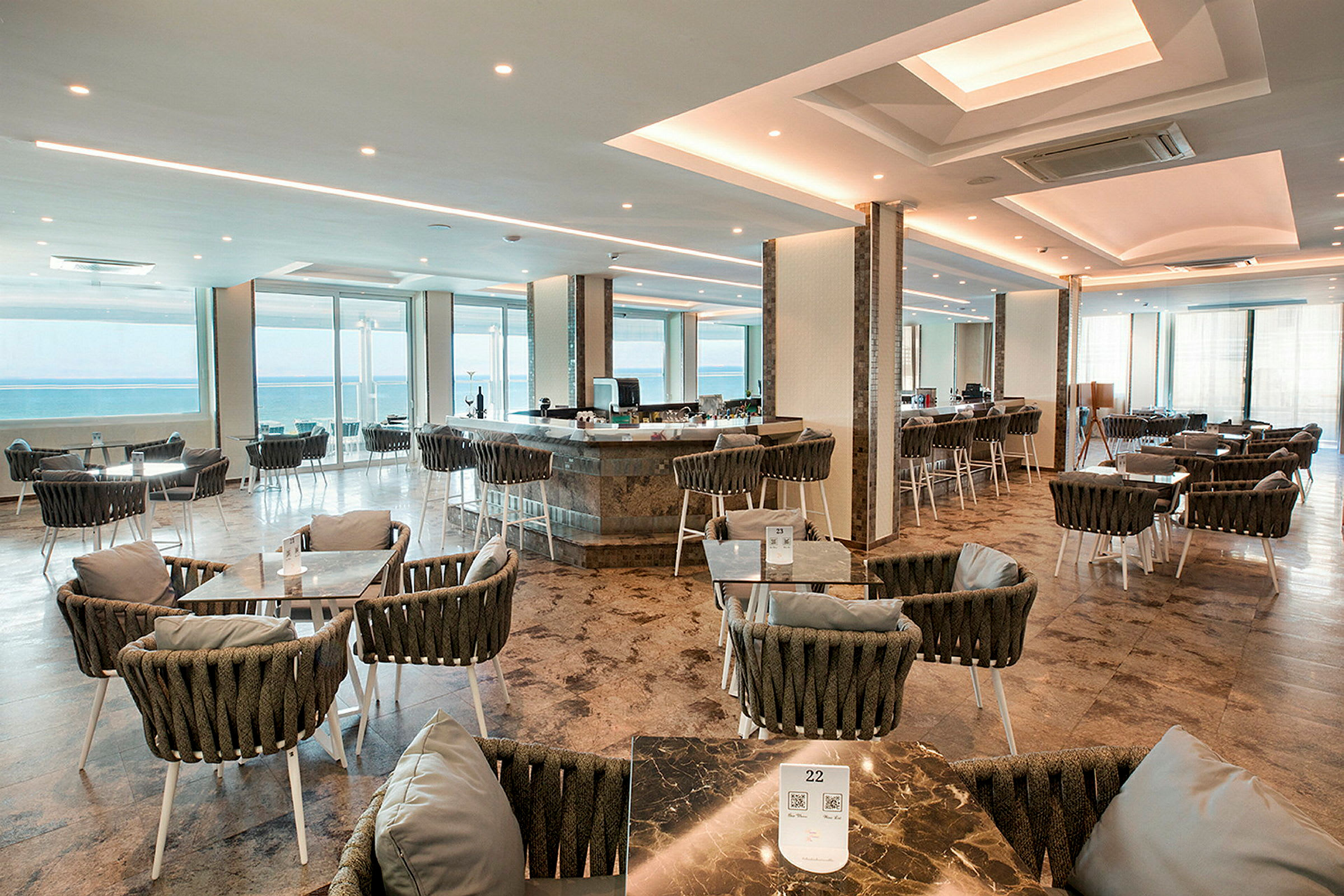 En rymlig restaurang med sittplatser och utsikt över havet. (AI-genererad text)