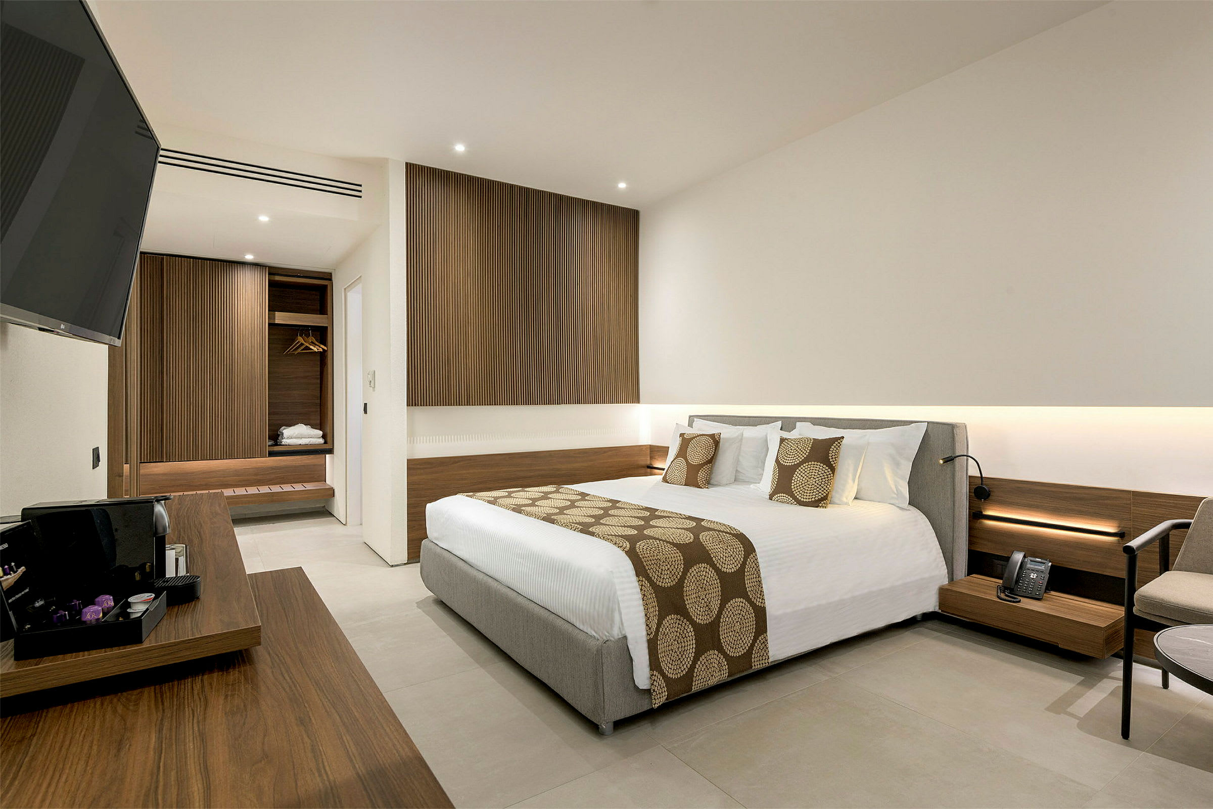 Hotellrum med modern inredning, inklusive en stor säng och trädetaljer. (AI-genererad text)