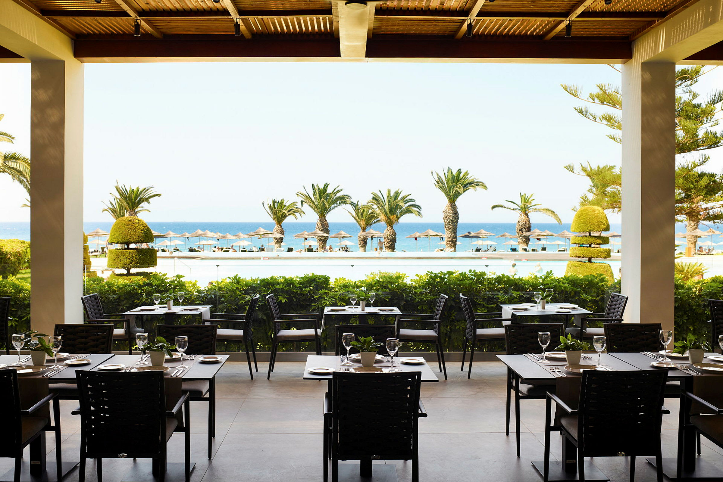En restaurang med utsikt över havet och tropiska palmer. (AI-genererad text)