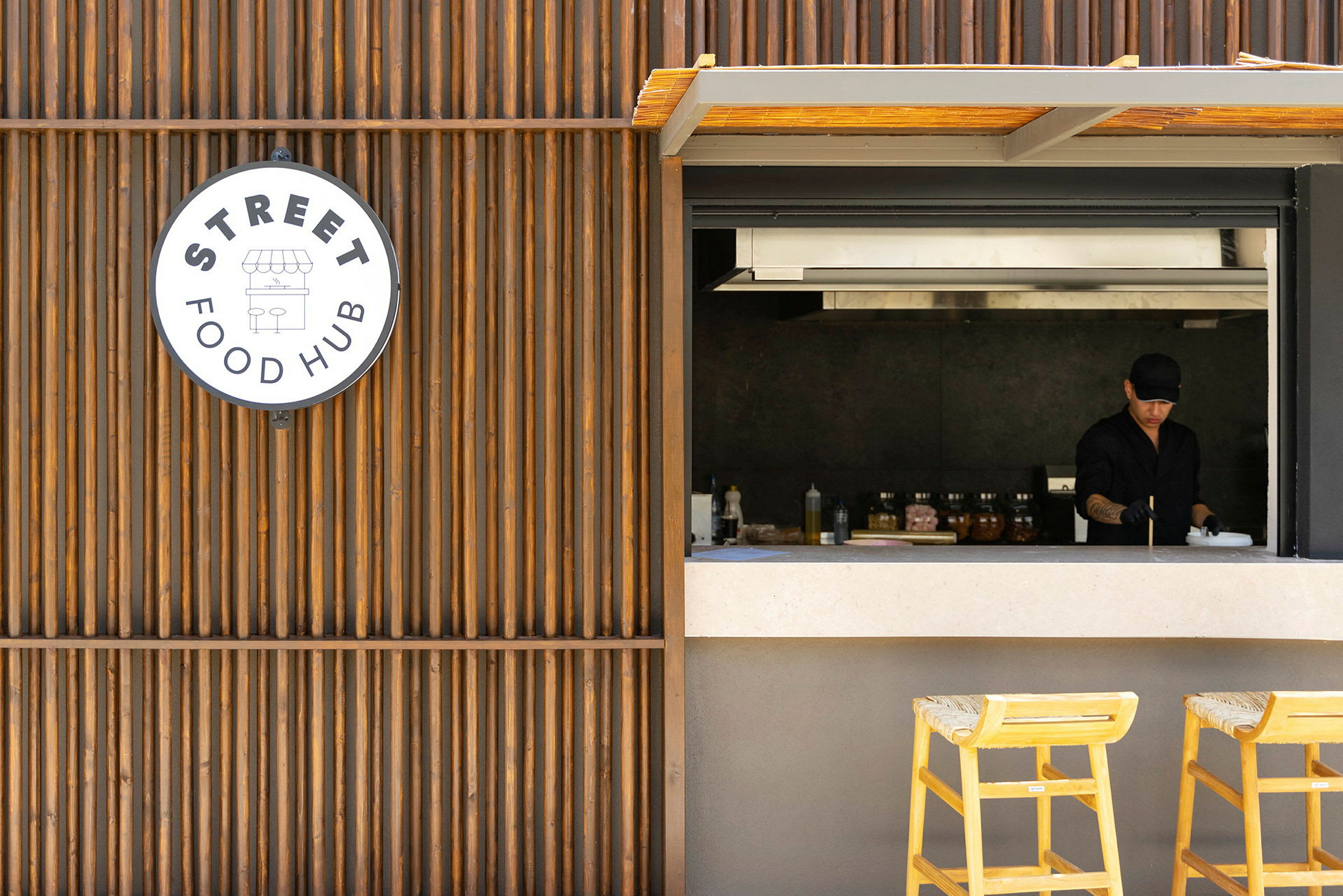 Utsikt mot en matservering med en öppet serveringslucka och en skylt som visar 'Street Food Hub'. (AI-genererad text)
