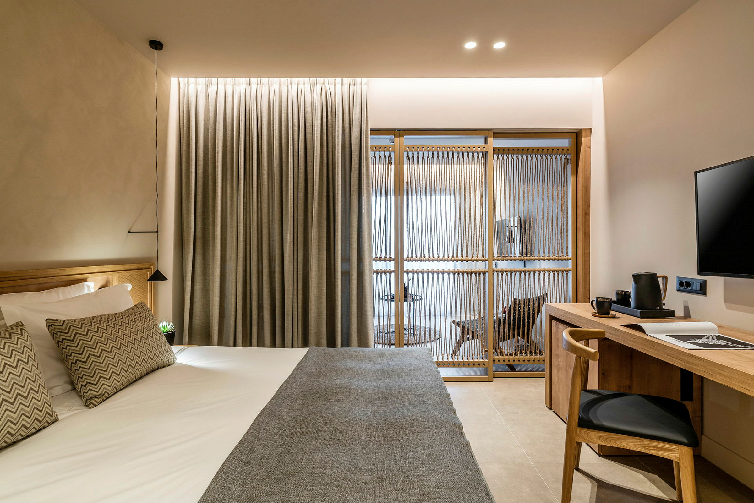 Hotellrum med modern inredning, inklusive säng, skrivbord och avskiljande vägg. (AI-genererad text)