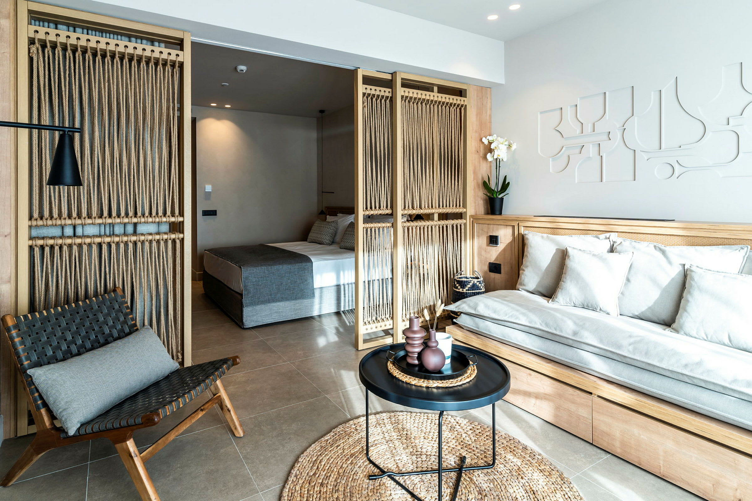 Modernt hotellrum med sittplats och separat sovdel. (AI-genererad text)