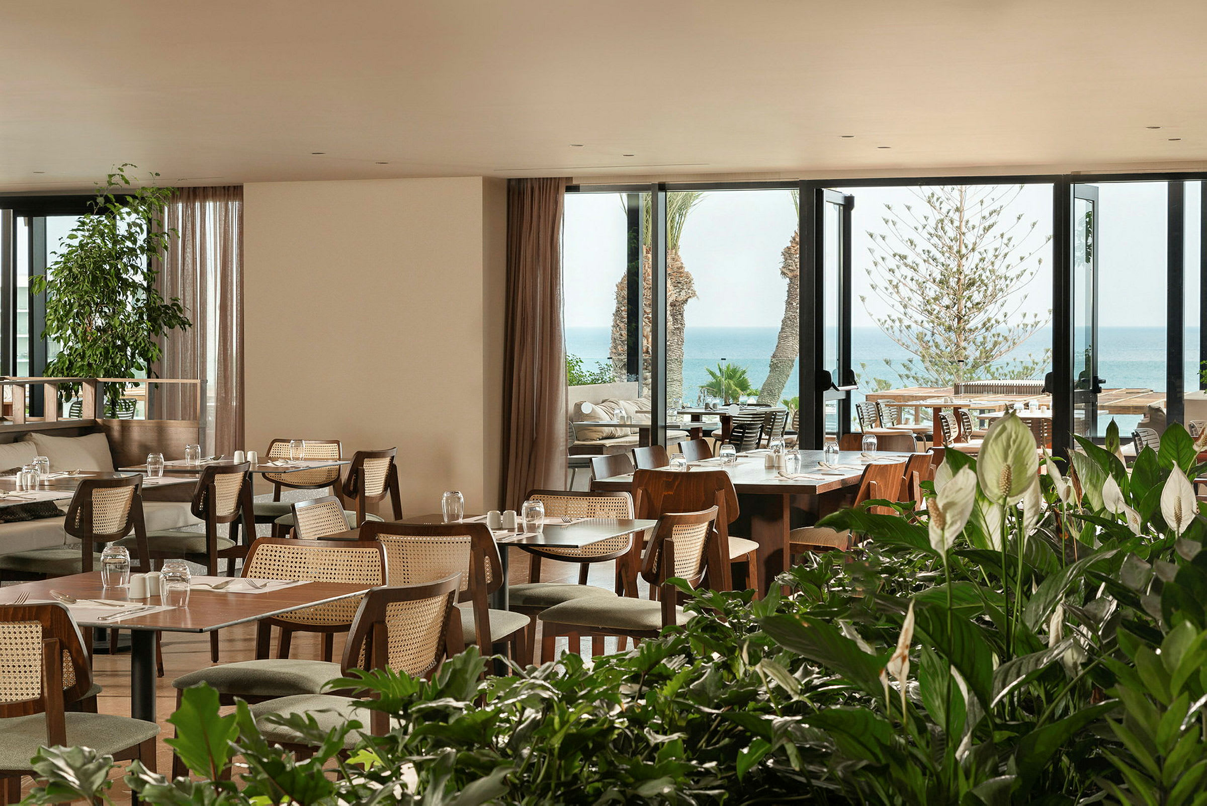 En restaurang med utsikt över havet och omgiven av grönska. (AI-genererad text)