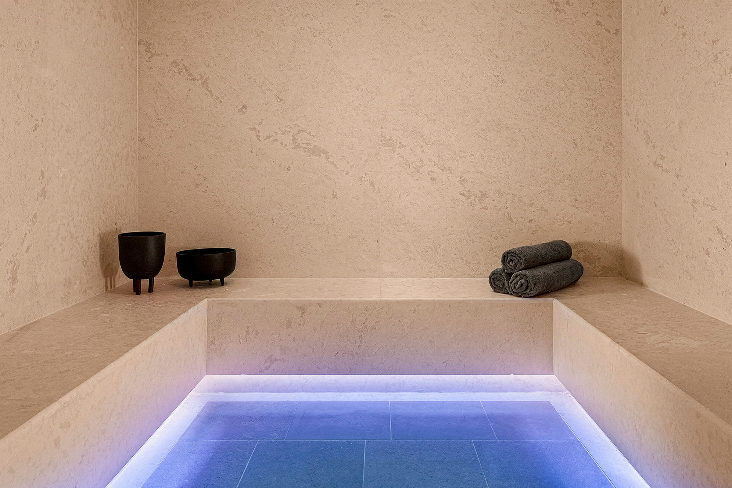 Ett spa-område med bänkar och upplyst golv. (AI-genererad text)