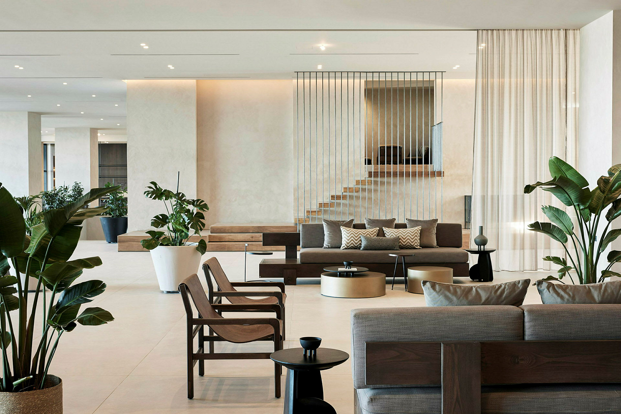 Modern hotellobby med soffor, stolar och gröna växter. (AI-genererad text)