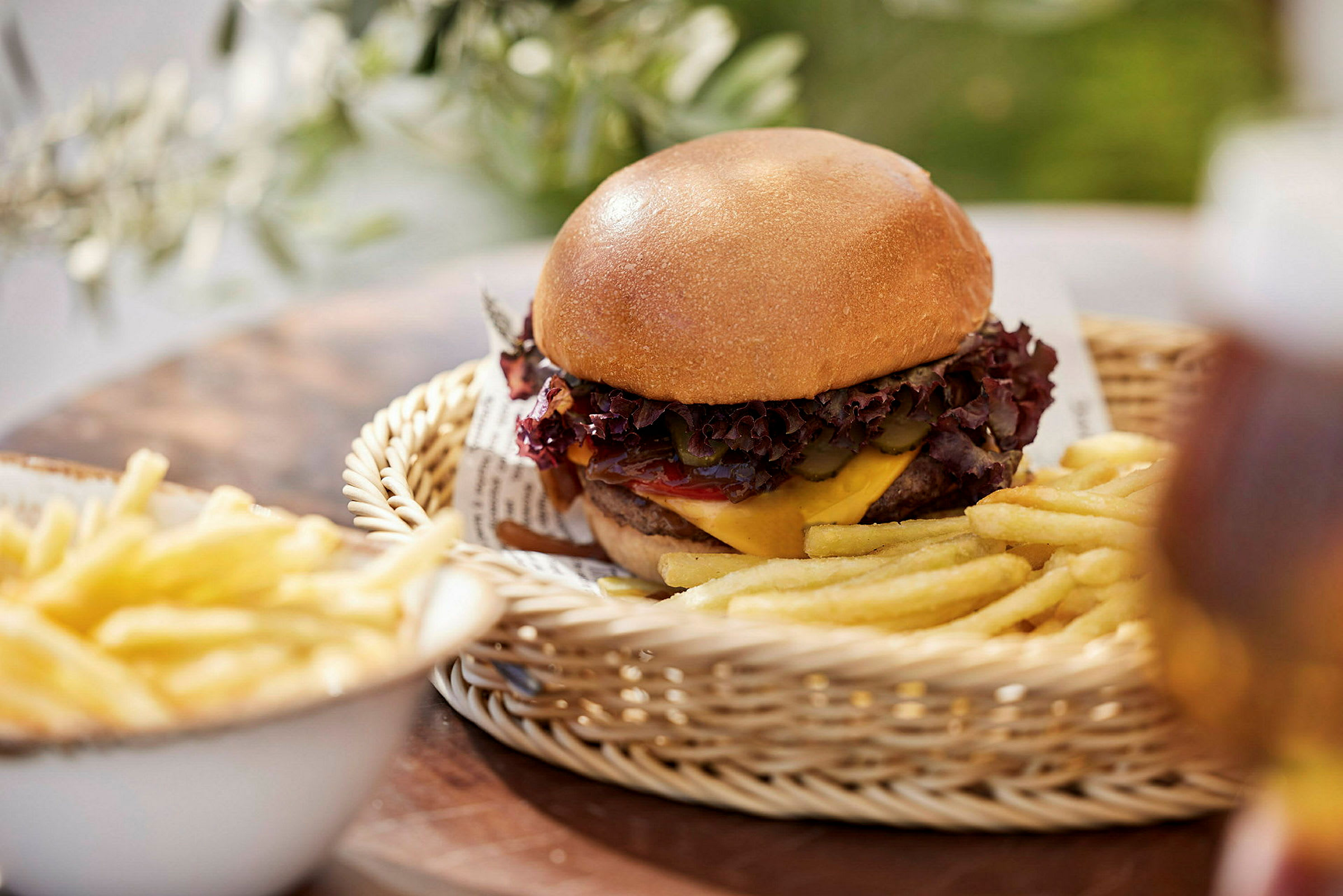 En hamburgare med pommes frites serverad i en korg. (AI-genererad text)