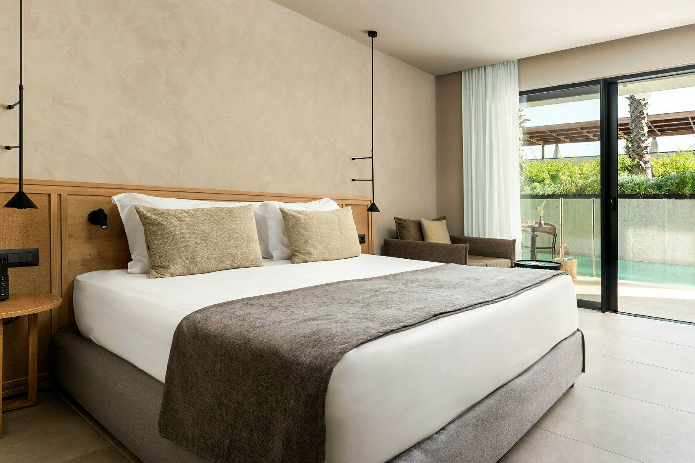 Ett hotellrum med en stor säng och en glasdörr som leder till poolområdet. (AI-genererad text)
