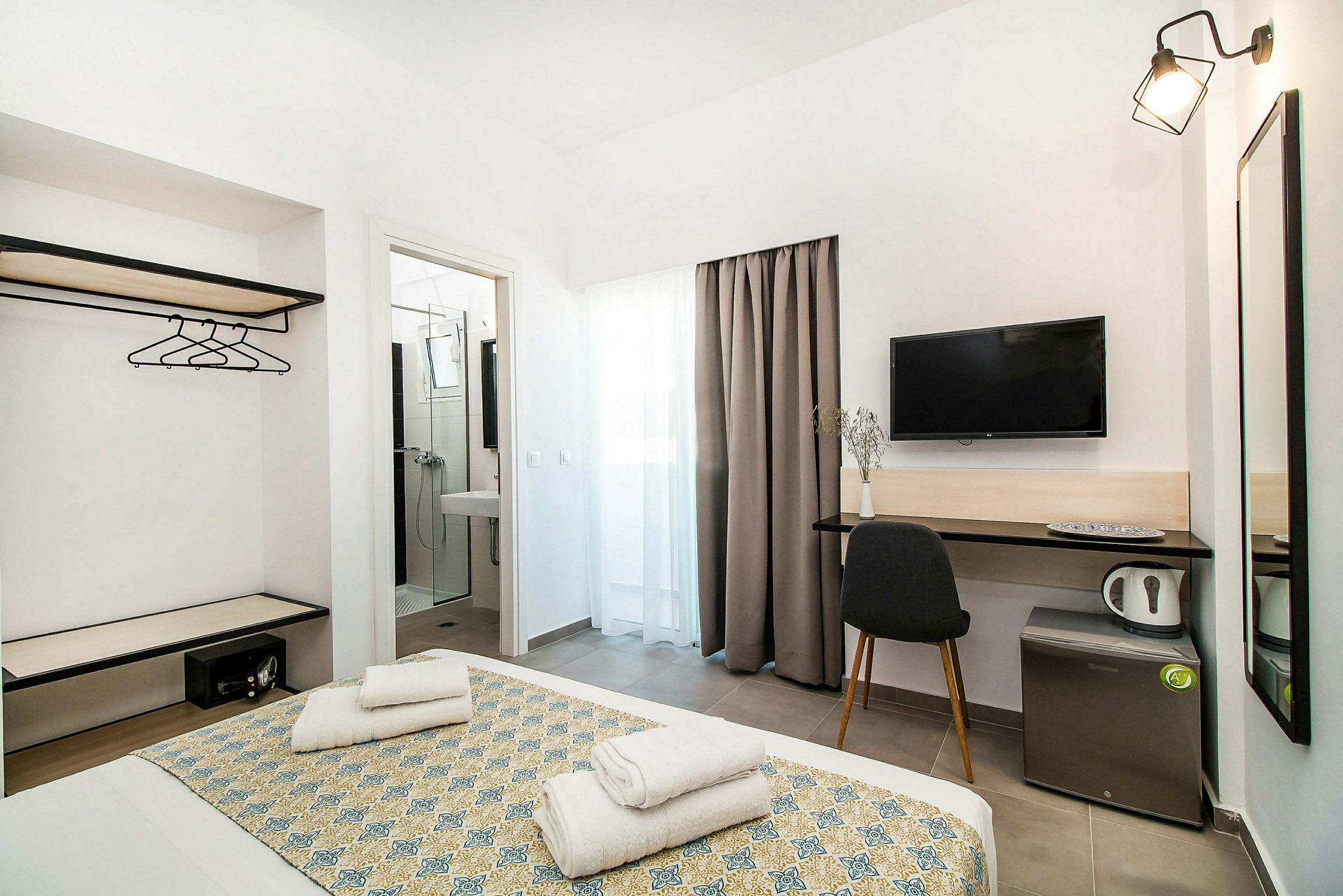 Hotellrum med säng, tv, skrivbord och badrum. (AI-genererad text)