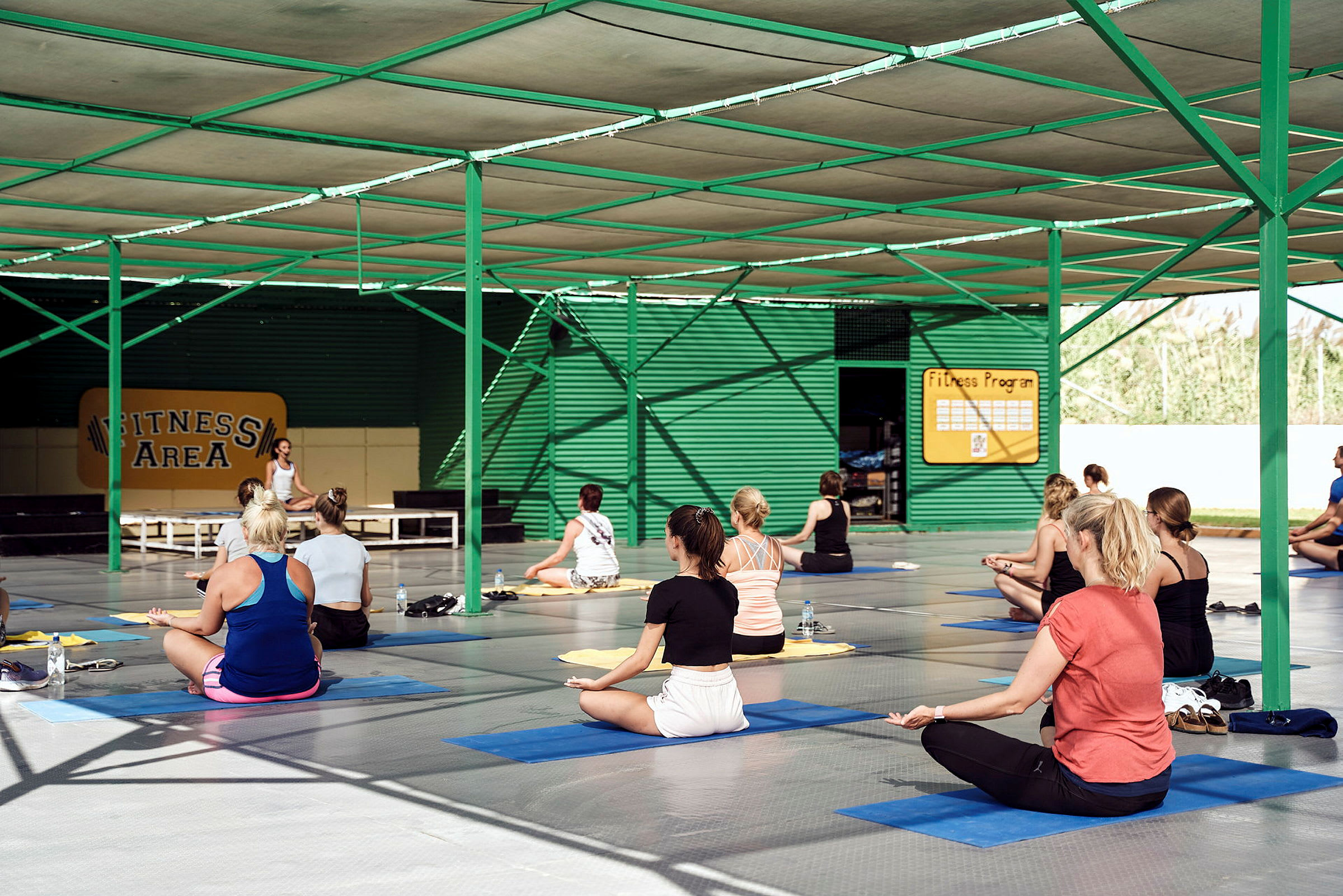 Personer utför träning på yogamattor i en täckt fitnessanläggning. (AI-genererad text)