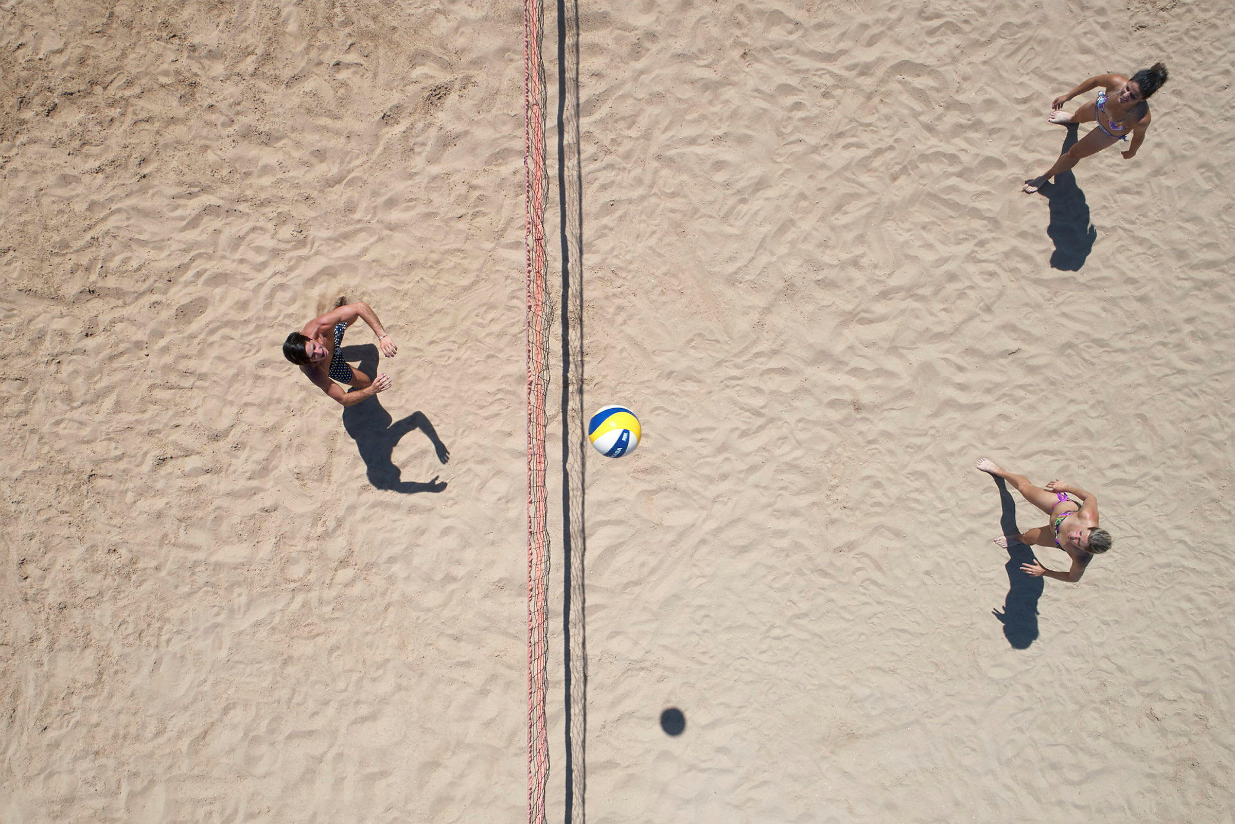 Två personer spelar beachvolleyboll. (AI-genererad text)