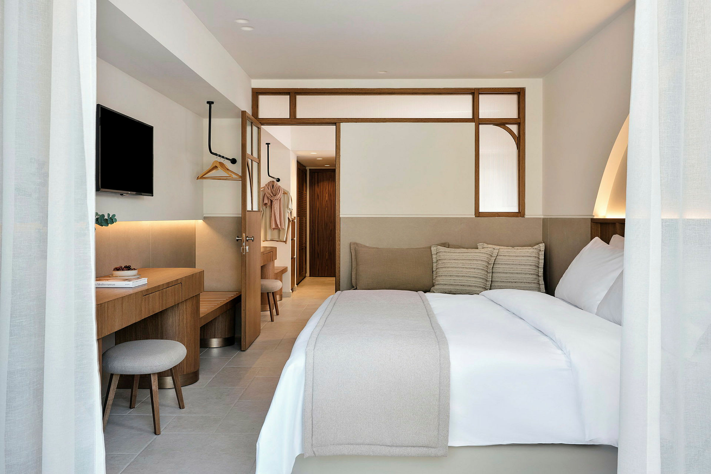 Hotellrum med en stor säng, en skrivbordsplats och en TV på väggen. (AI-genererad text)