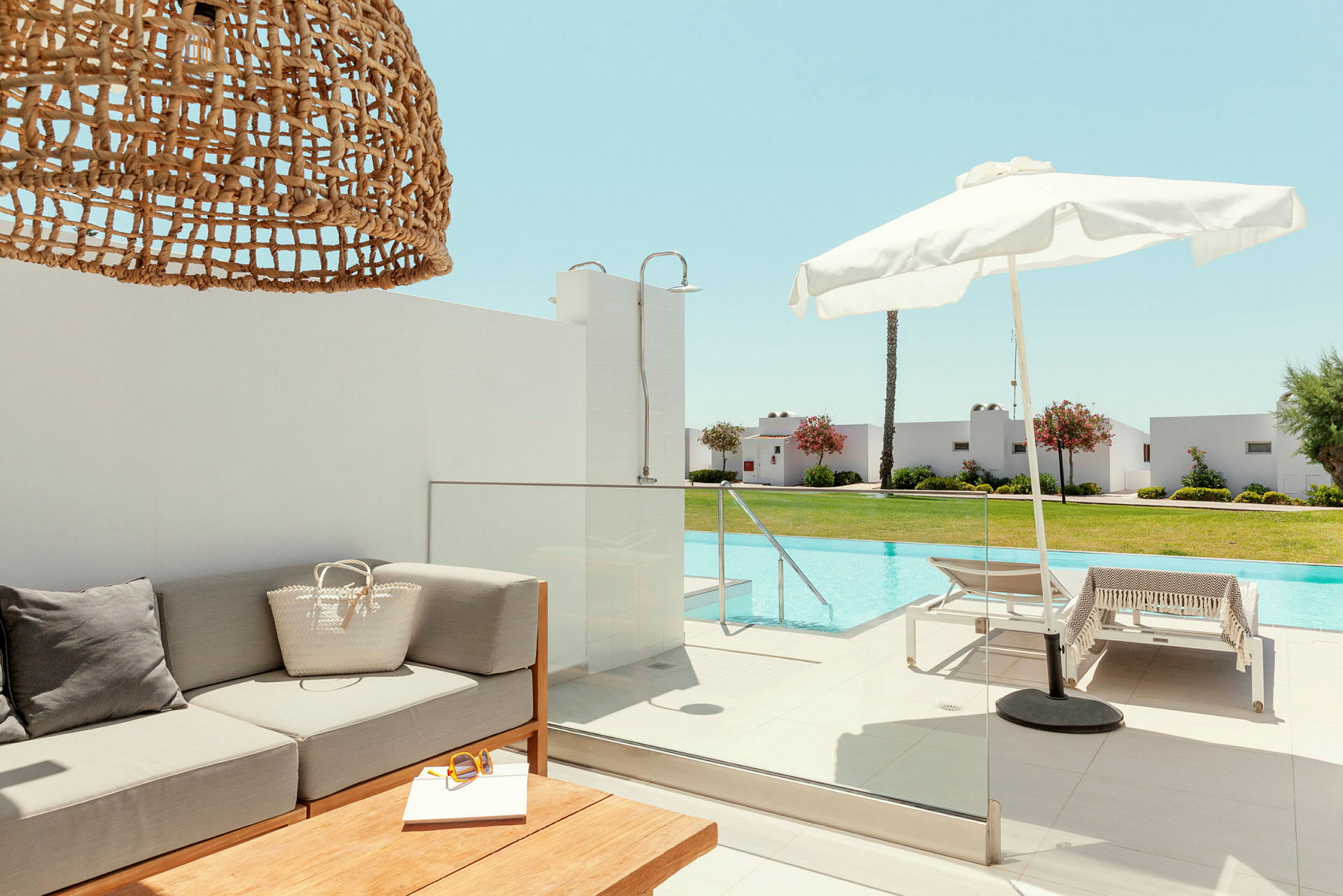 Utomhusmiljö med soffa, parasoll och pool. (AI-genererad text)