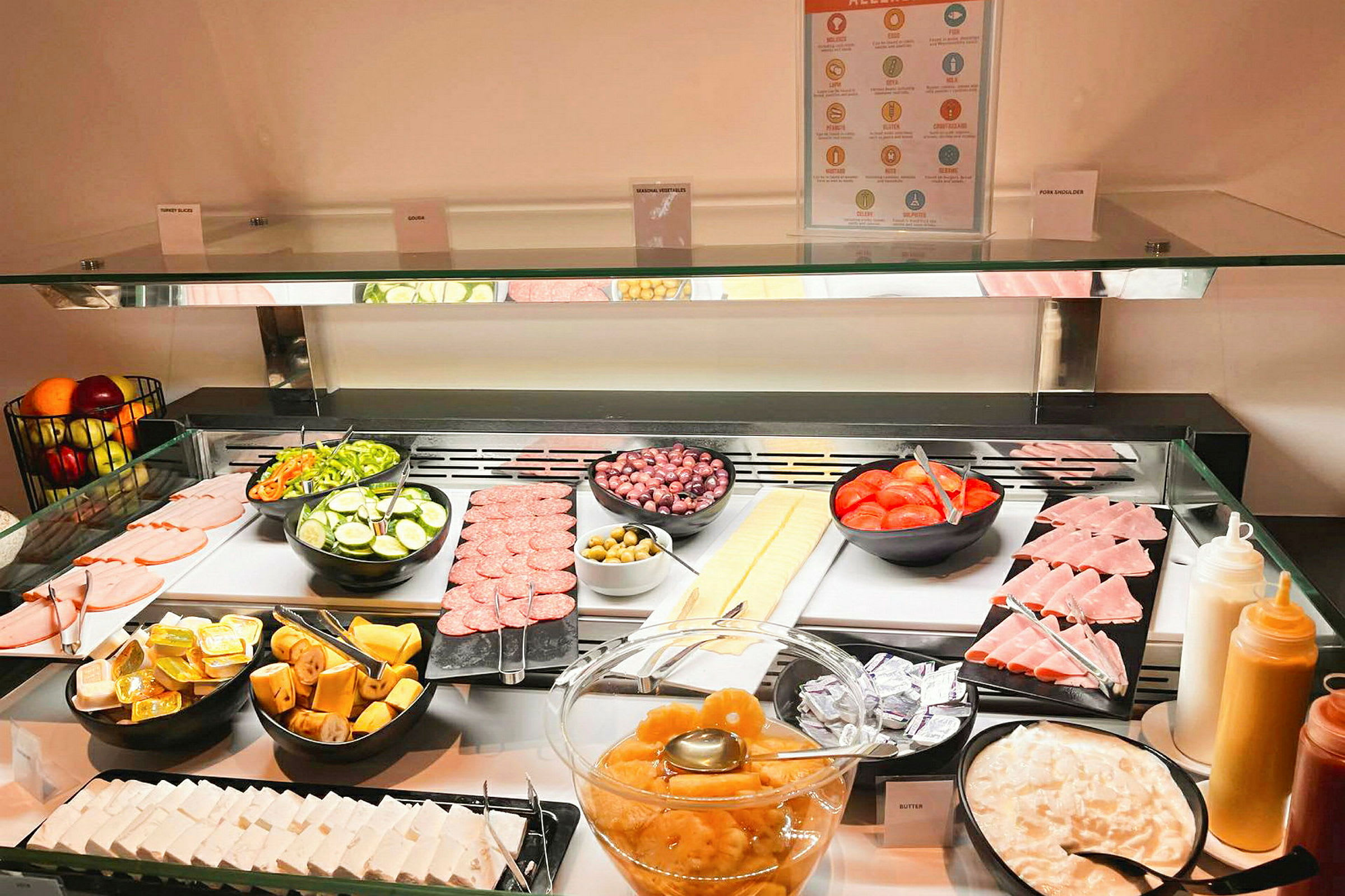 En buffé med skivade grönsaker, köttprodukter, frukt och olika tillbehör. (AI-genererad text)