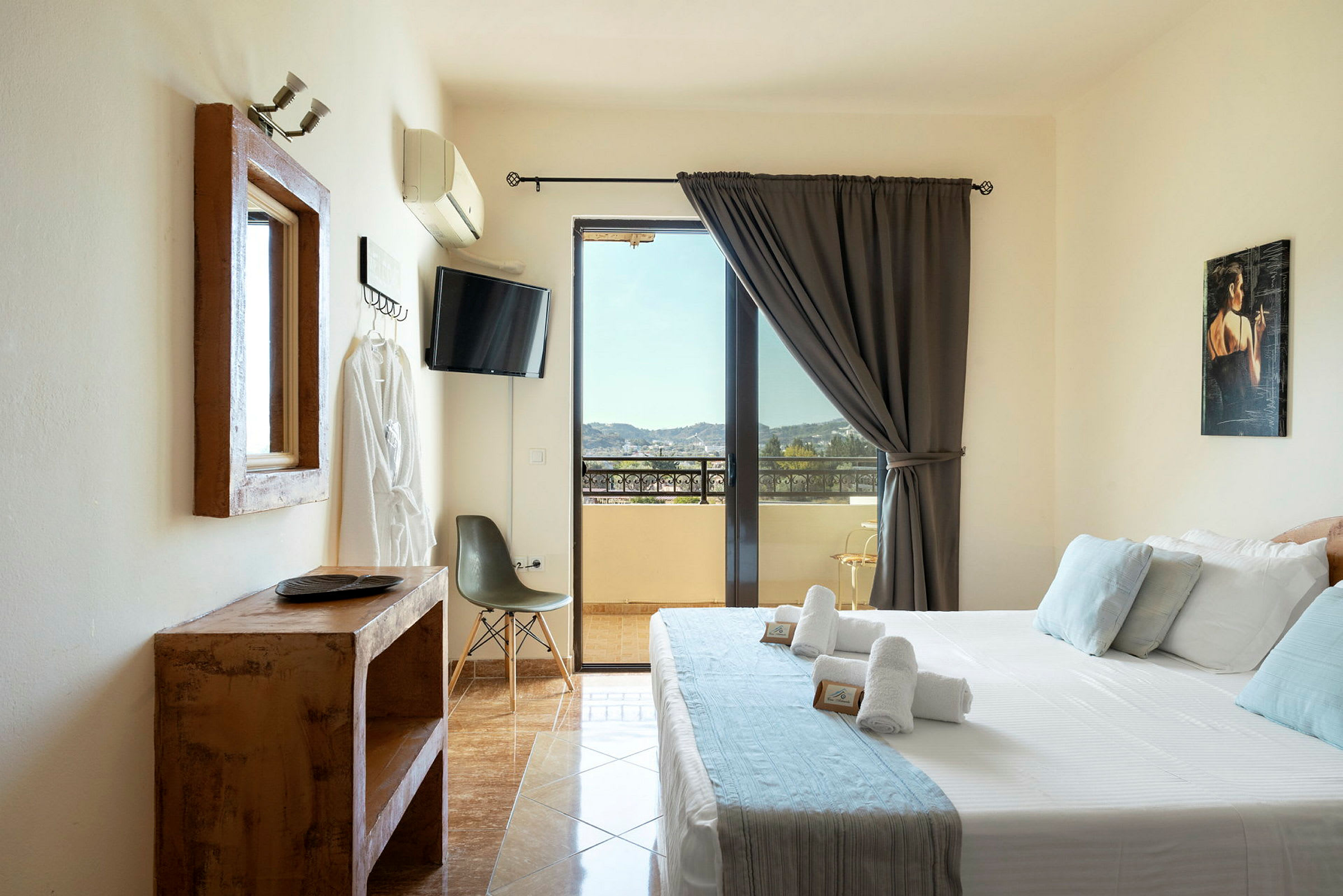 Ett hotellrum med en säng, tv, stol och utsikt över en balkong. (AI-genererad text)