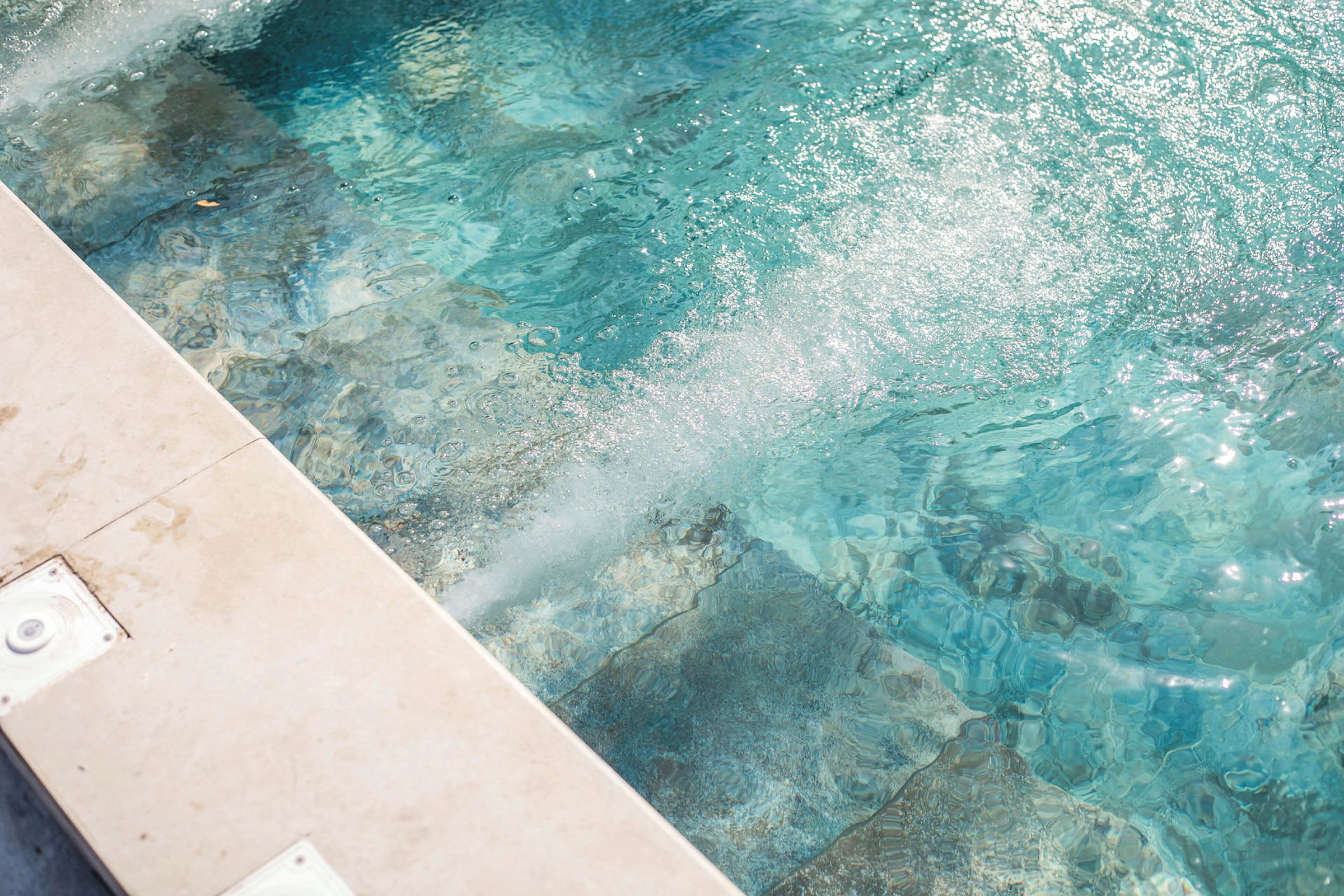 Närbild av klart vatten med bubblor i en pool. (AI-genererad text)