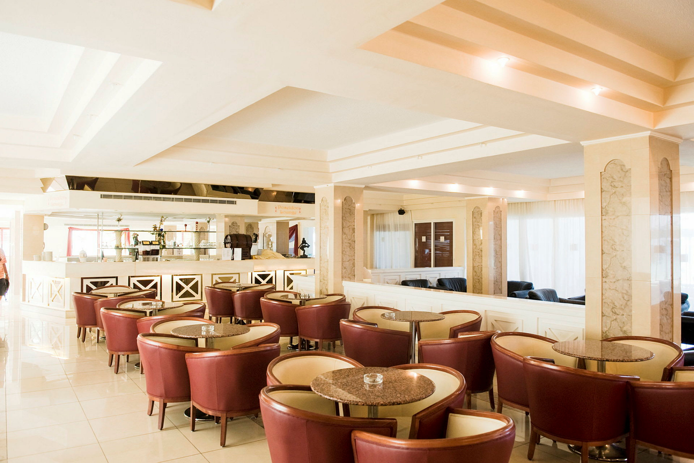 Bild av en modern hotellounge med röda stolar, runda bord och ett väl upplyst interiör. (AI-genererad text)