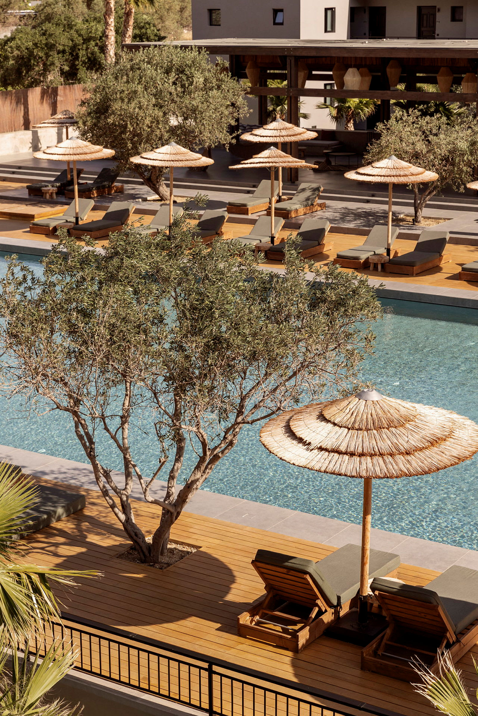 Bild av en pool med solstolar och parasoller i ett hotellområde. (AI-genererad text)