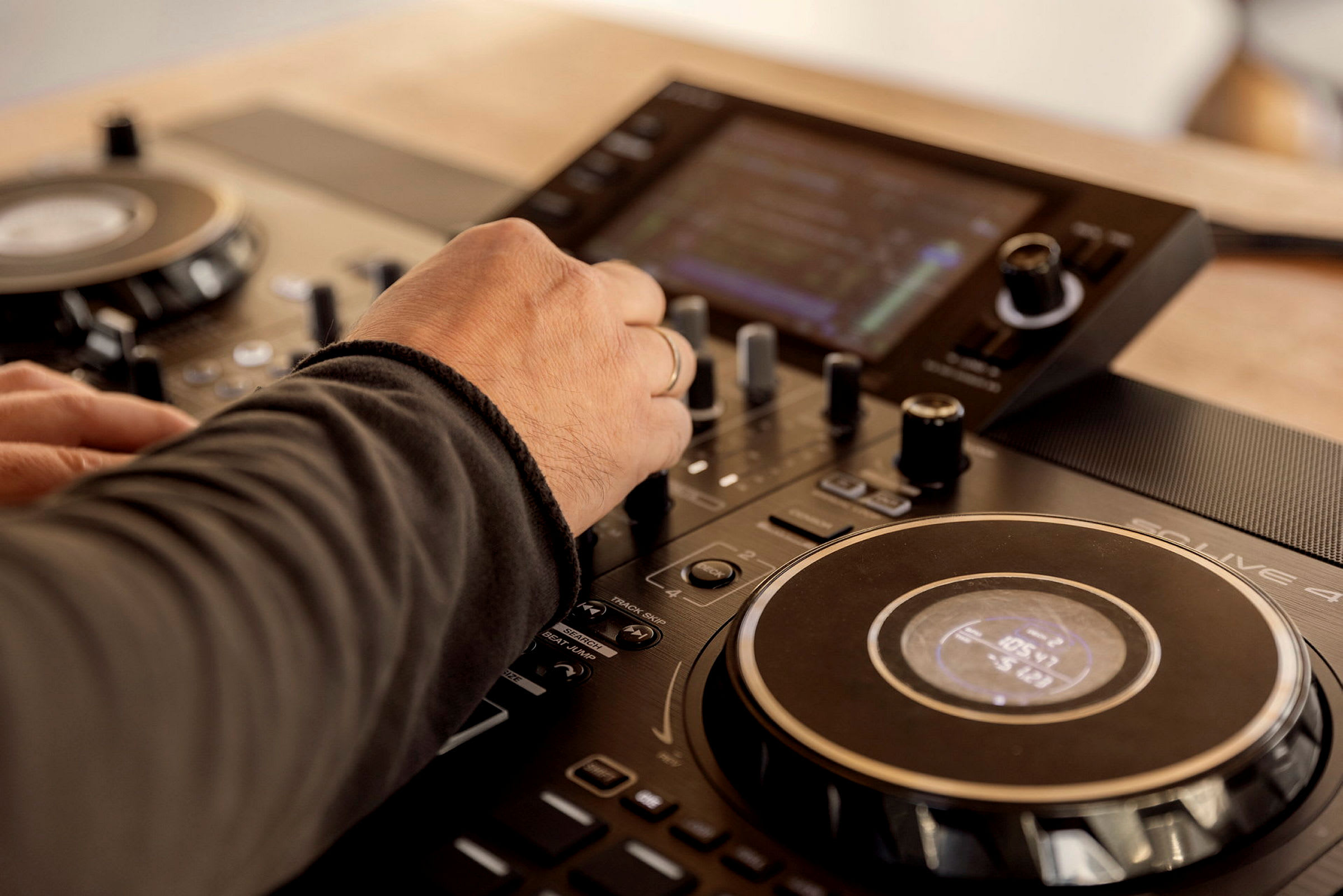 En hand justerar reglage på en DJ-mixer. (AI-genererad text)