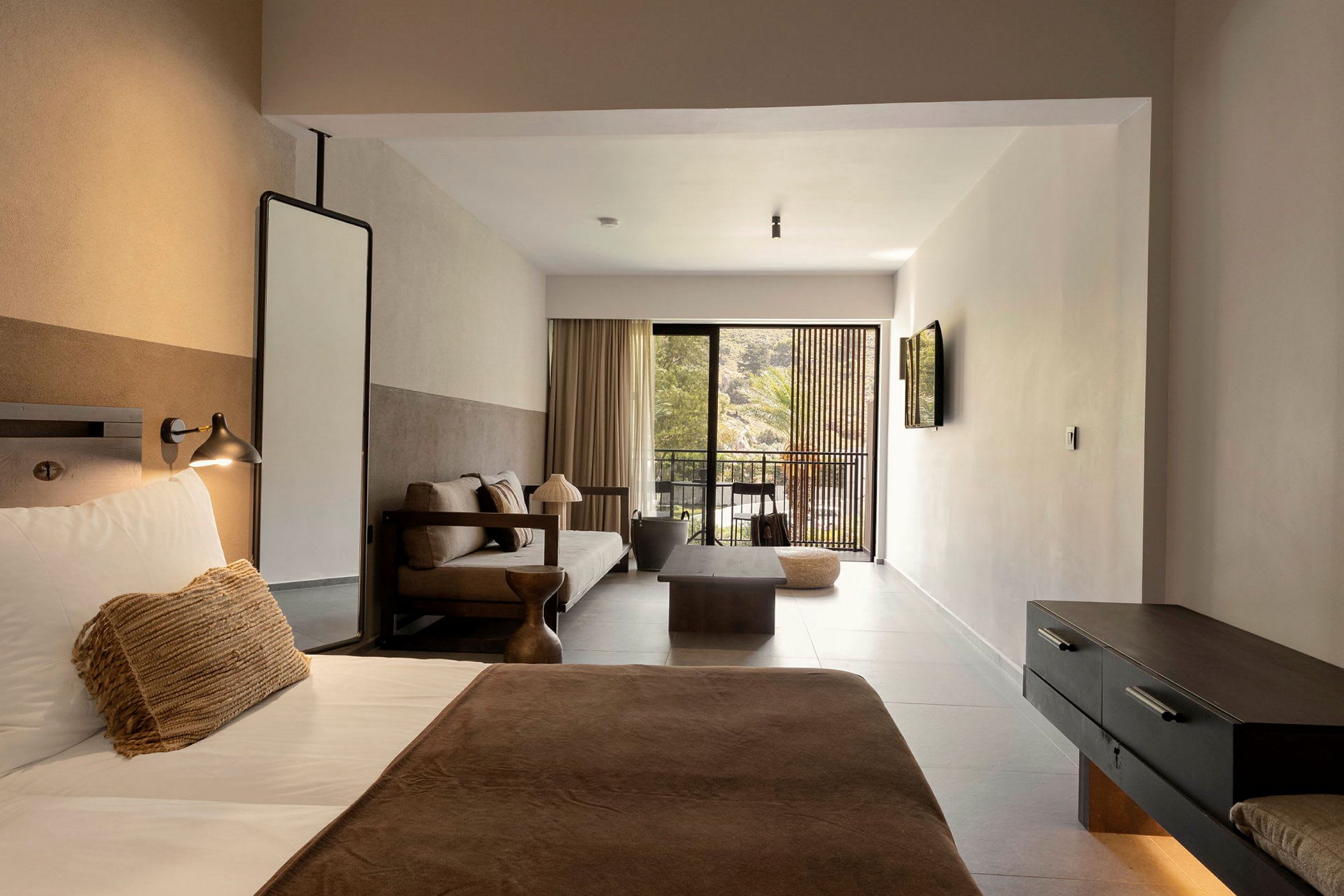 Ett hotellrum med säng, soffa och uteplats. (AI-genererad text)