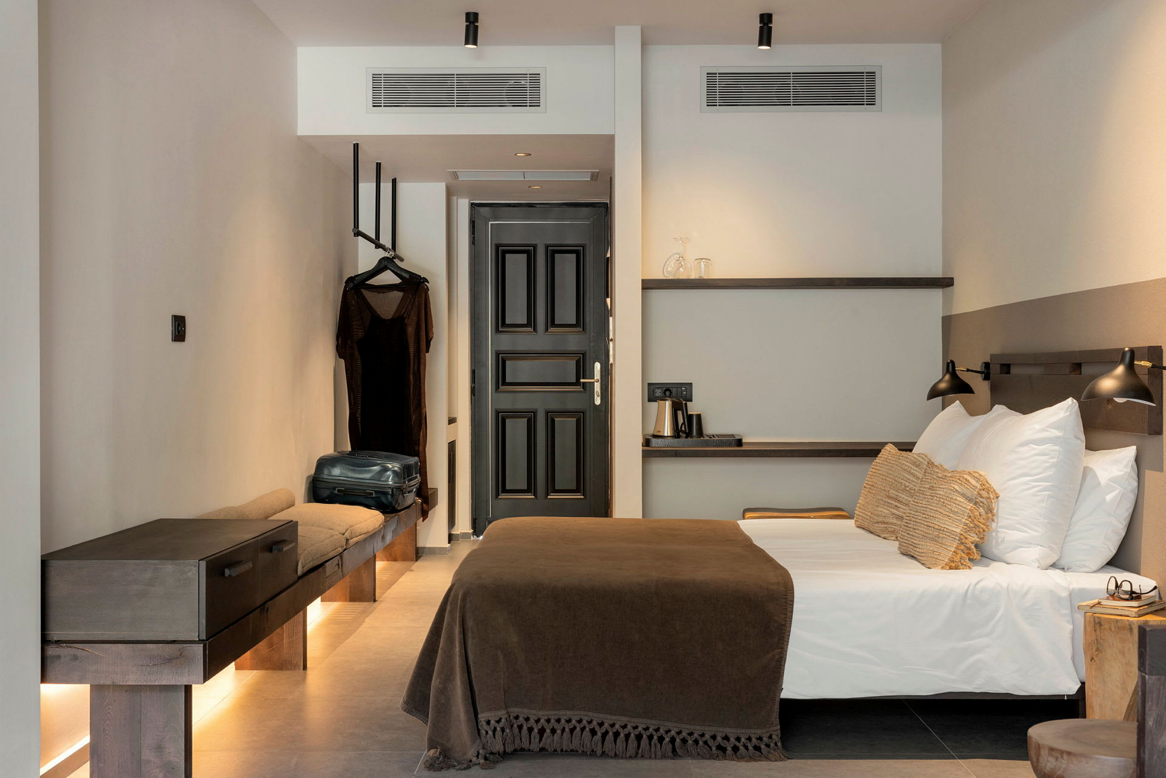 Modernt hotellrum med säng, färgkoordinerade möbler och inredningsdetaljer. (AI-genererad text)