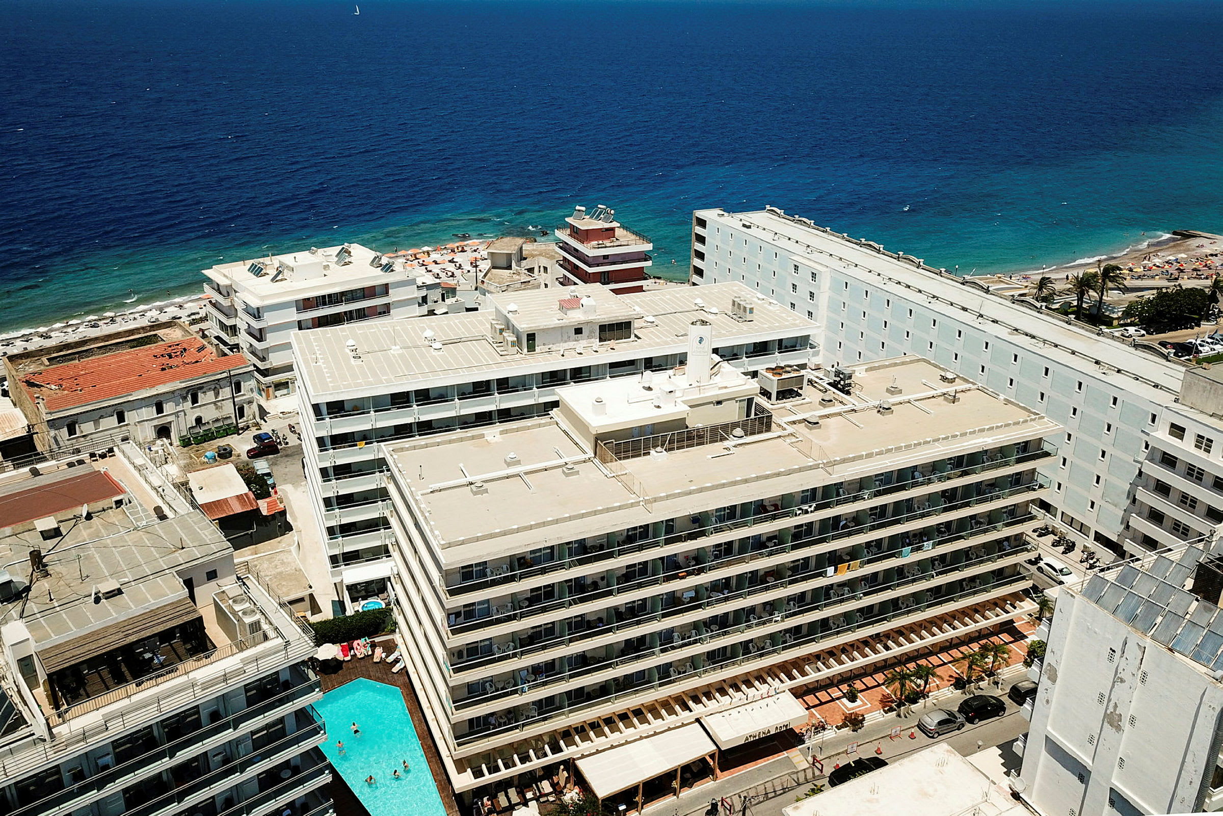 Flygbild över hotell och en strand vid havet. (AI-genererad text)